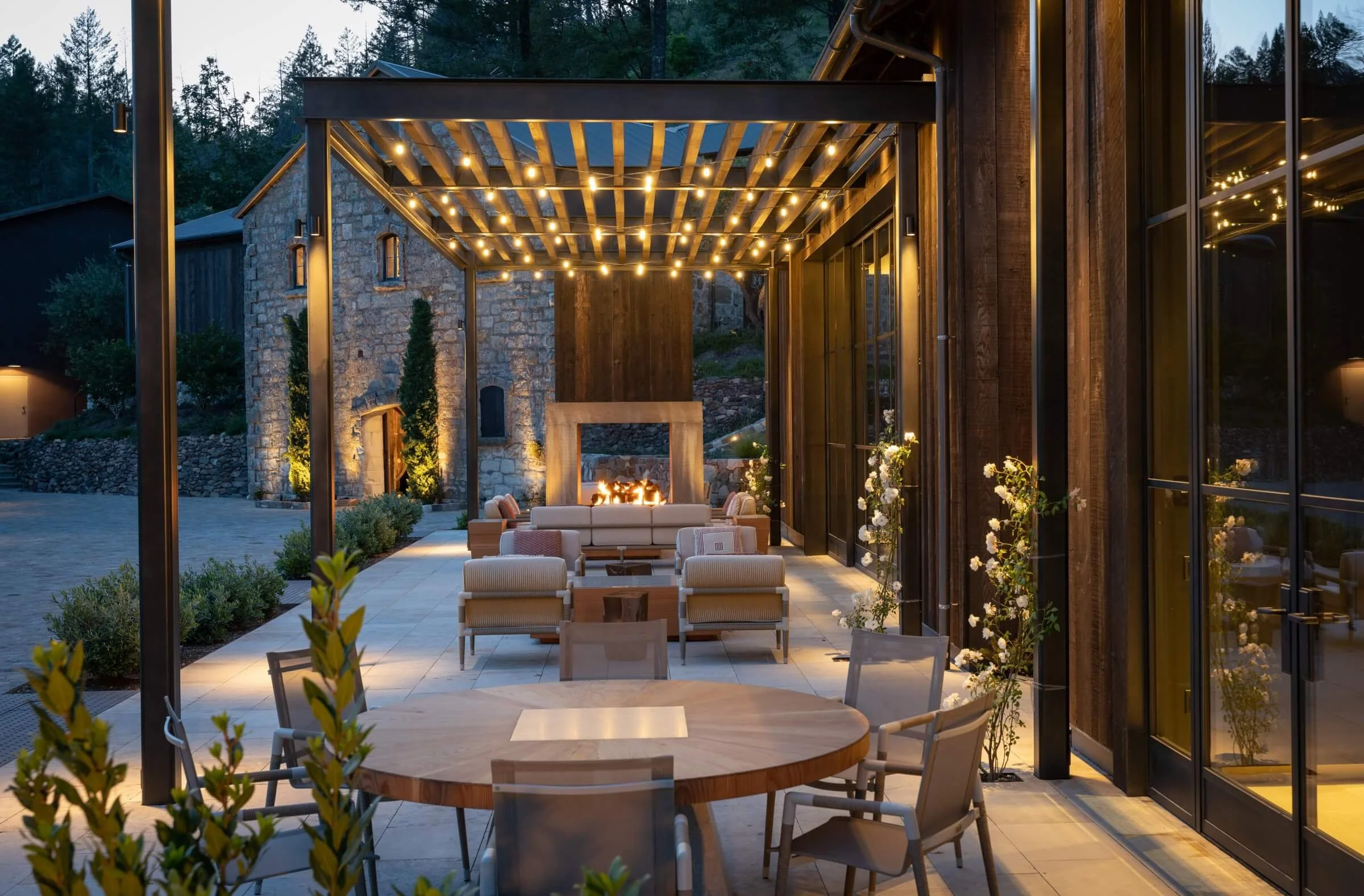 Outdoor lounge at Mayacamas Vineyards featuring a custom fire pit with subtle LED accent lighting and string lights integrated for Mount Veeder evening hospitality.