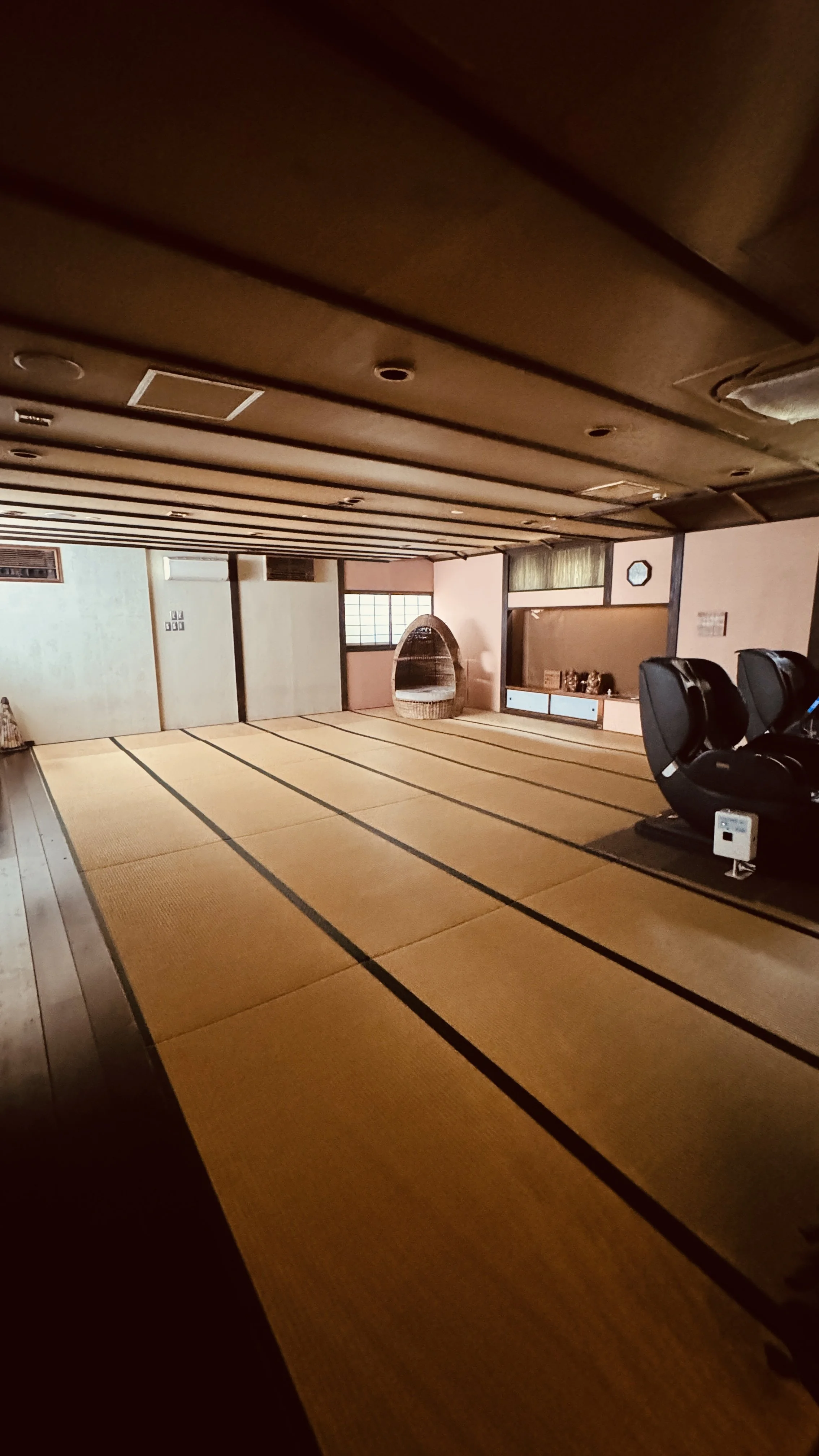 畳を敷いた和室の部屋。家具や装飾がなく、シンプルな空間で、窓や扉の障子や棚が見える。