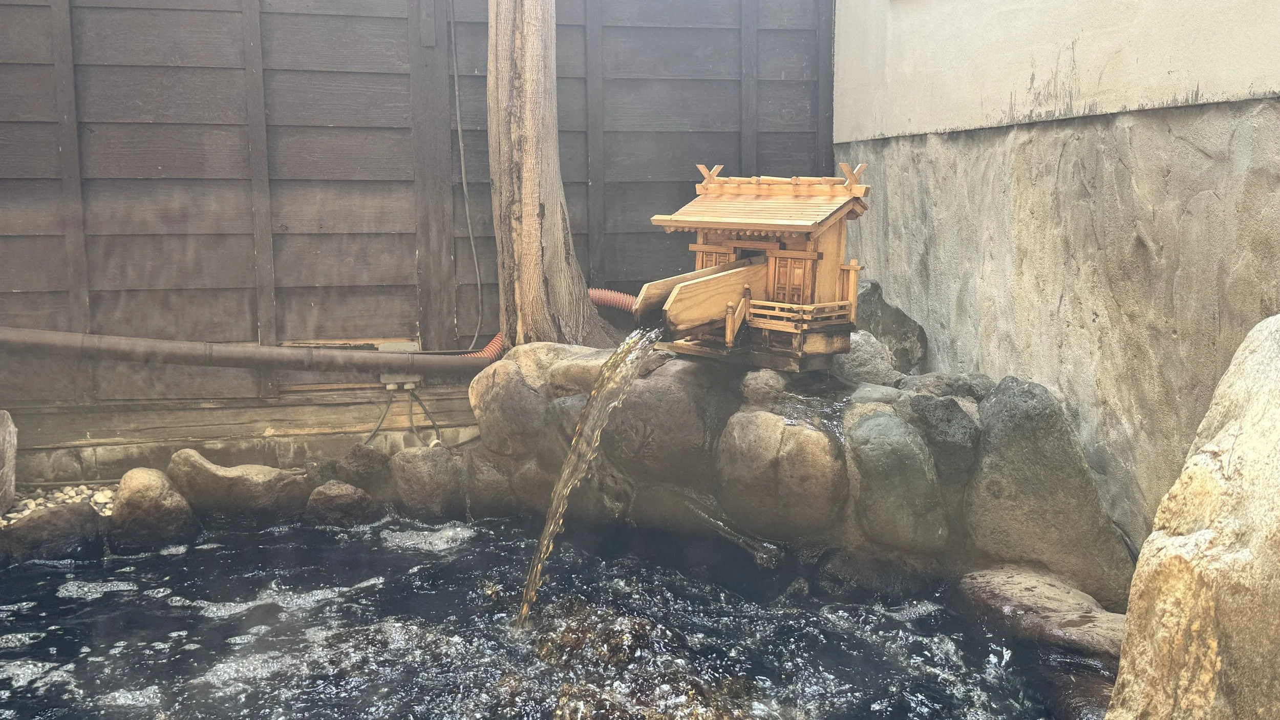 木製の神社の鳥居が水の流れに設置されている風景.
