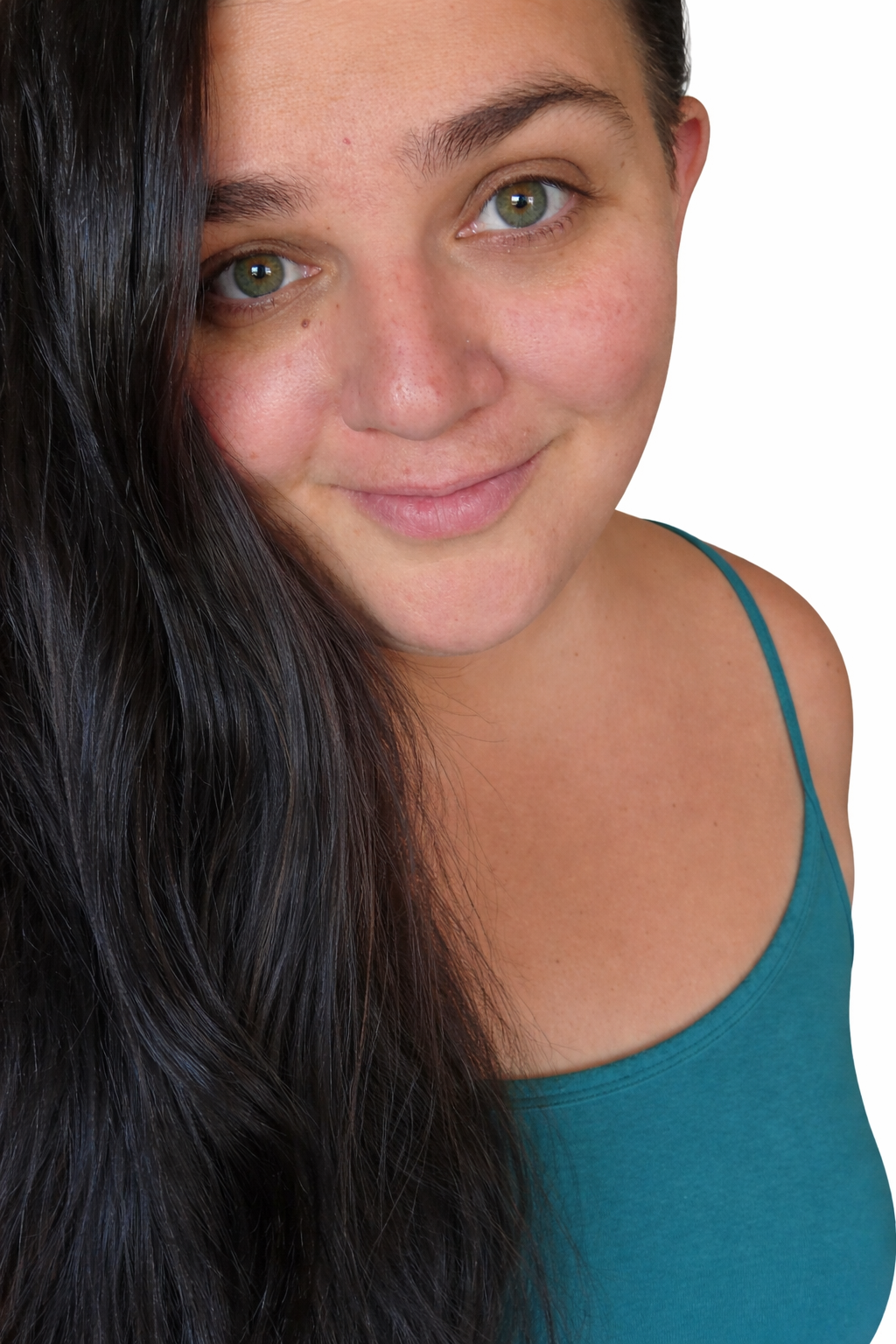 Close-up of a woman with long black hair, hazel eyes, and a light smile, wearing a teal tank top, with a plain white background.