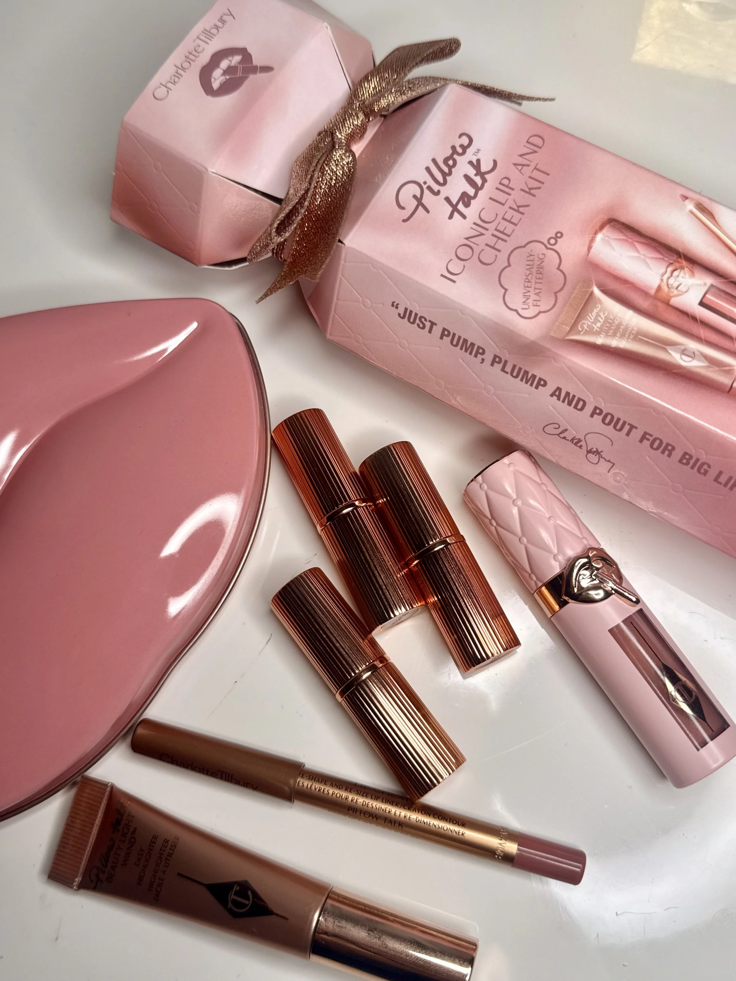 Charlotte Tilbury pillow talk makeup set with lipstick, lip liners, and additional lip products on a white surface.