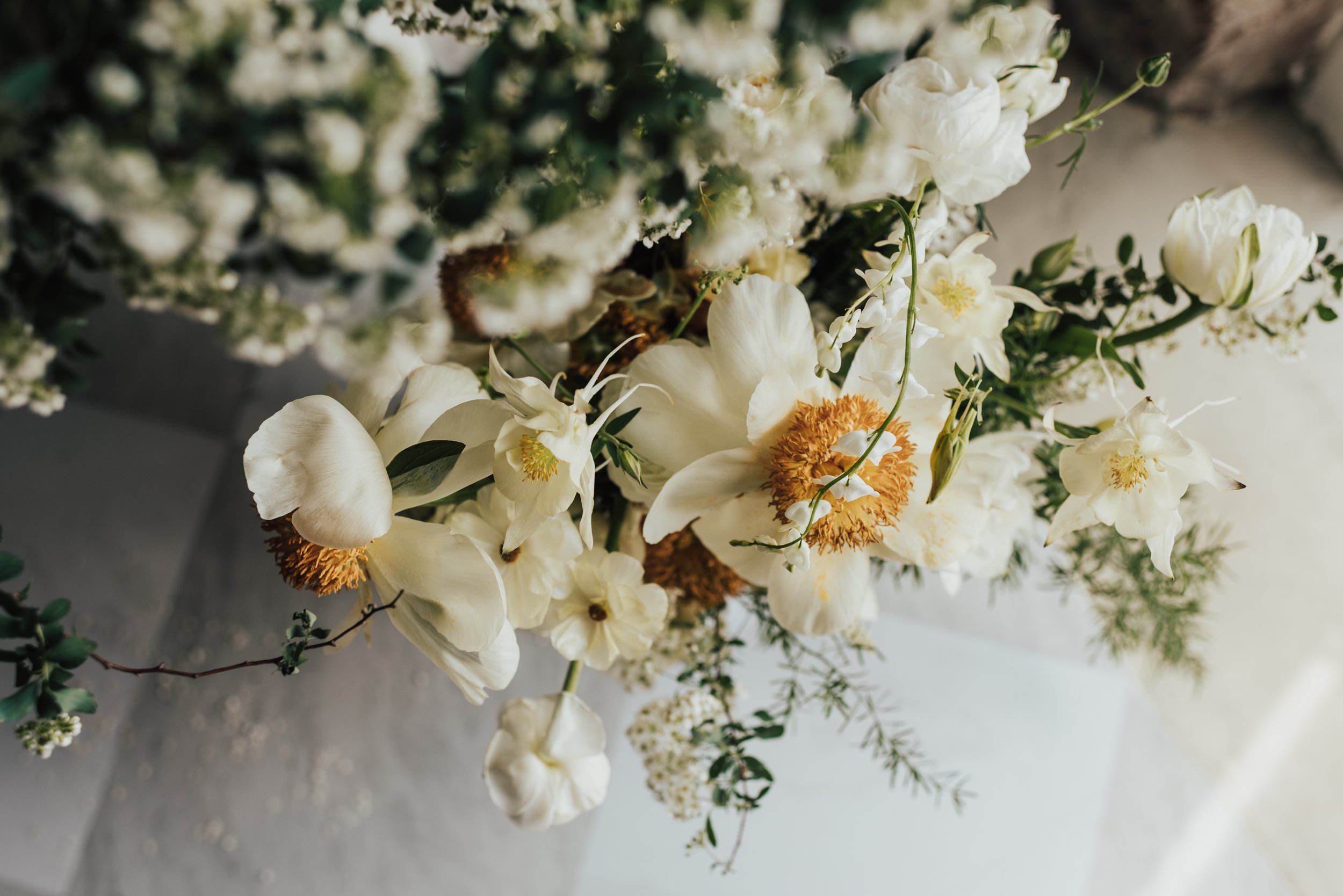 Yellow flowers mixed with greenery against marble floors. This photo was taken in Hayward, Wisconsin.