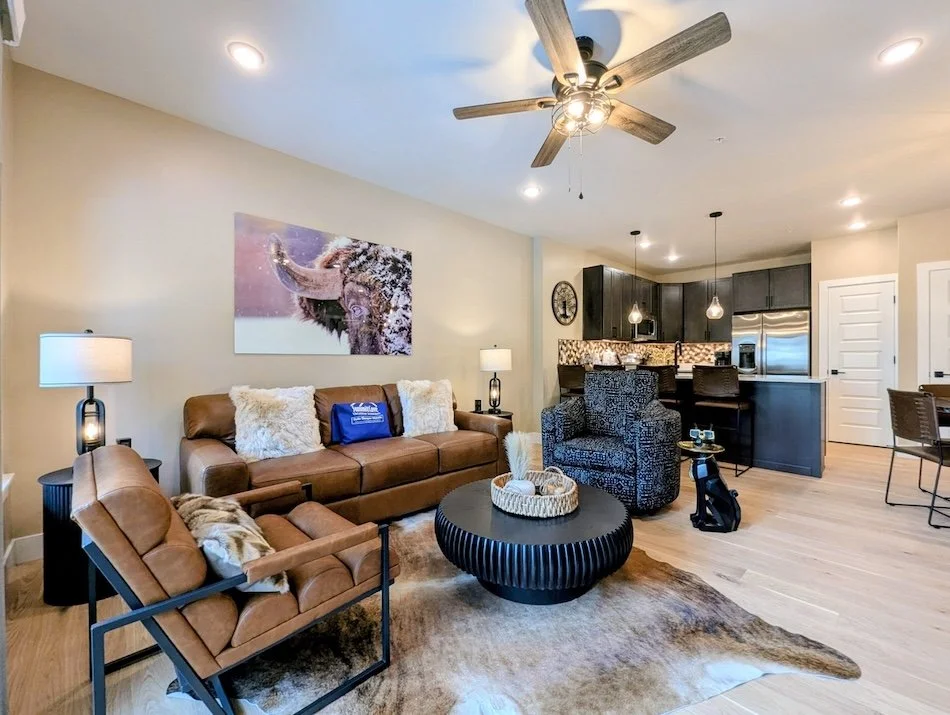 Luxury mountain vacation living room at Crystal Cottage, condo in Keystone, Colorado, including leather furniture and an open kitchen with stainless steel appliances and modern amenities for your vacation.