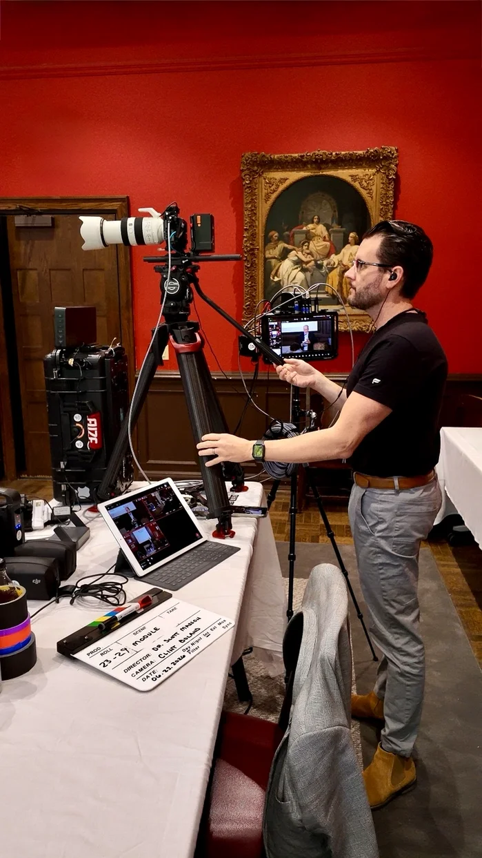 Conference video production camera operator monitoring a multi-camera recording setup during a live event