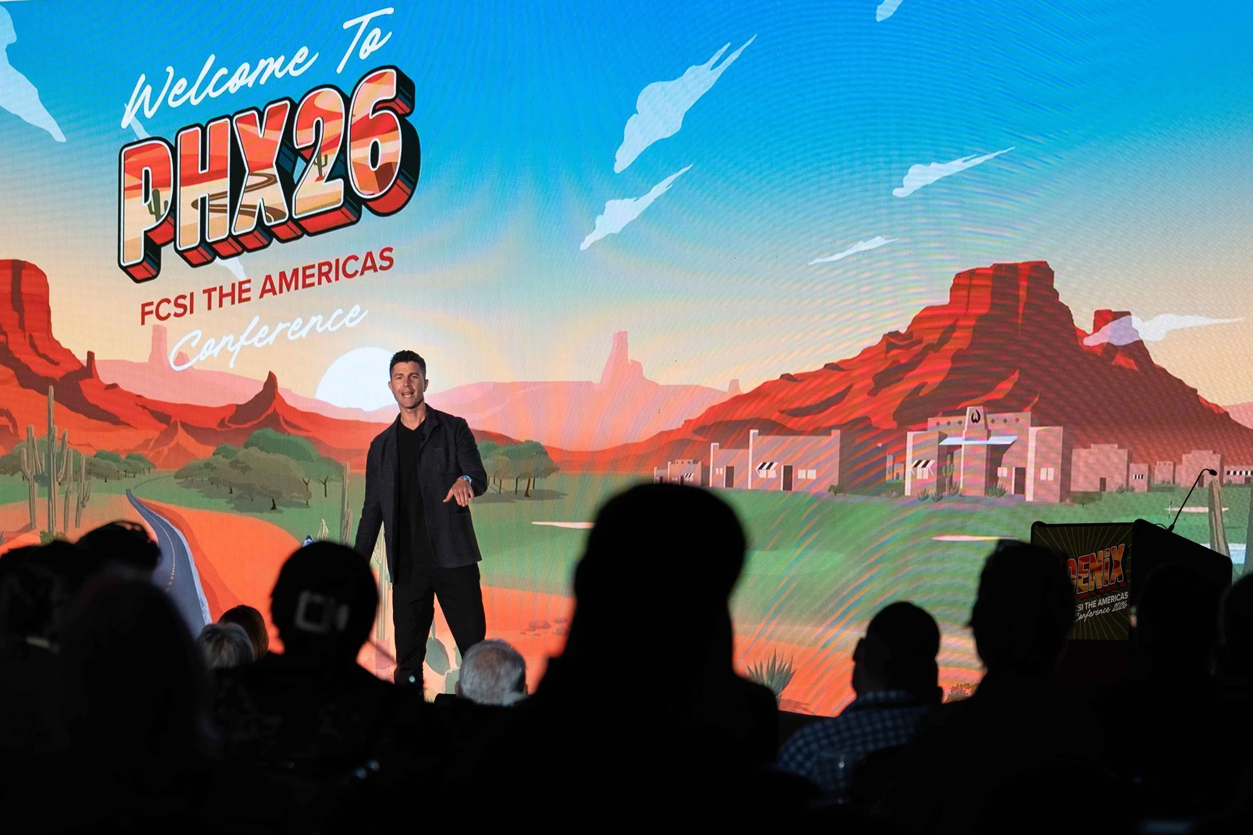 Keynote speaker presenting on stage at a large professional conference and industry event