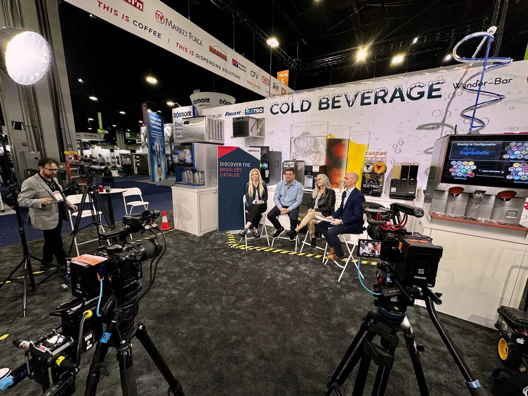 Multi-camera trade show video production setup filming an exhibitor panel on the convention floor