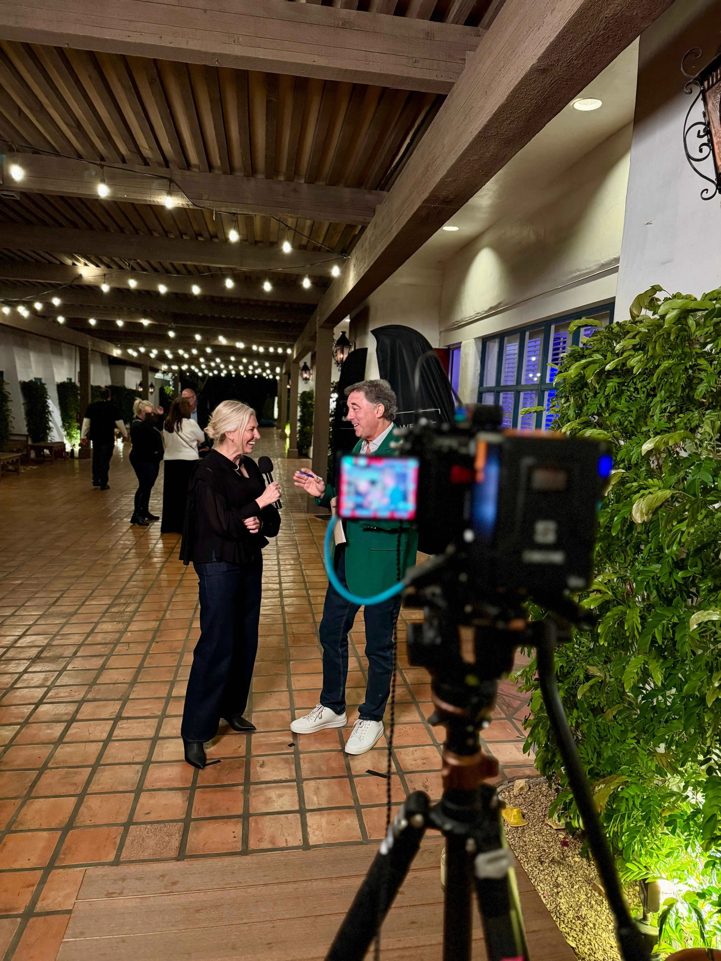 Conference videographer filming an attendee interview on location at a professional industry event