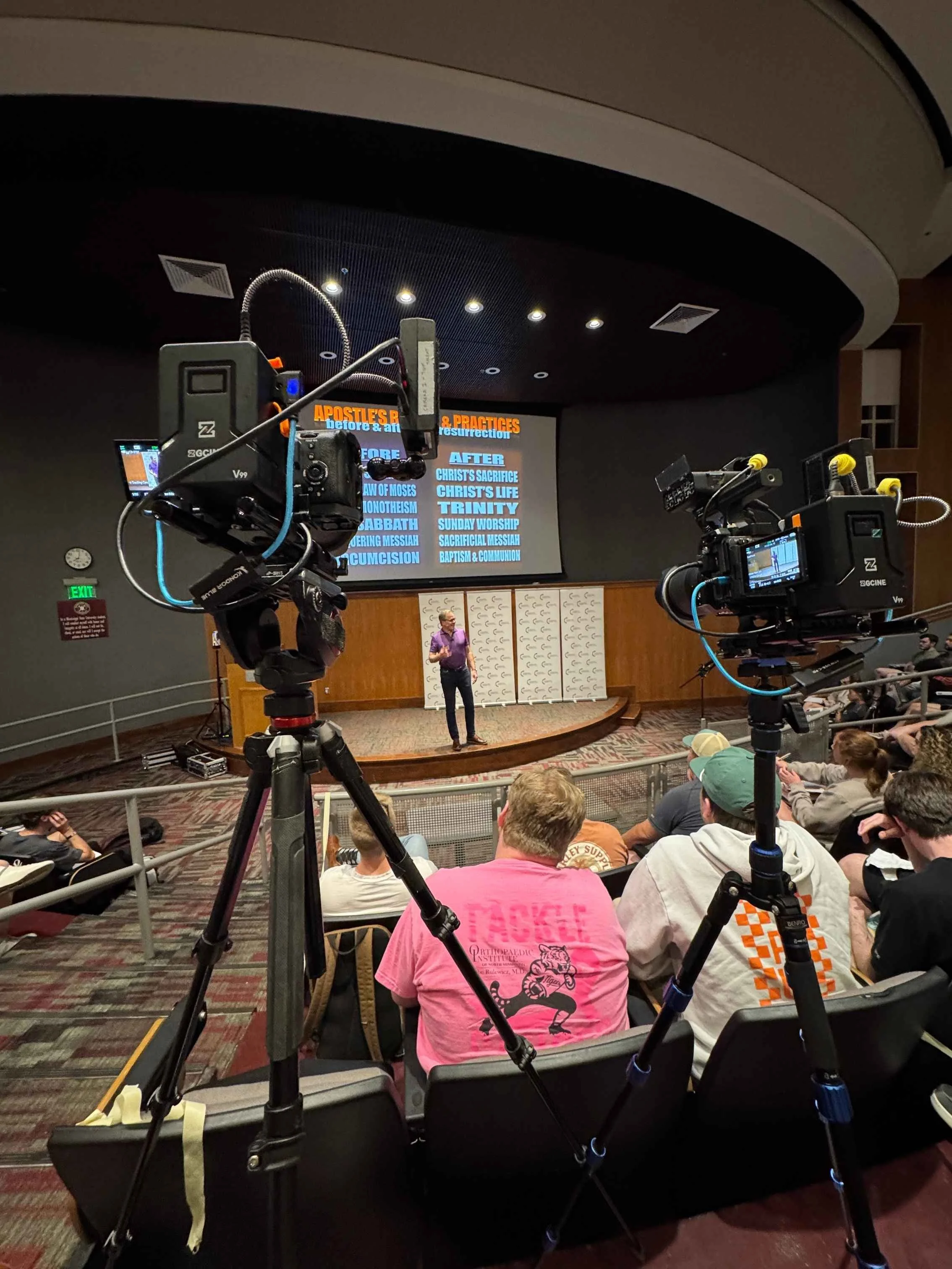Multi-camera video production setup capturing a speaker presentation at a live conference