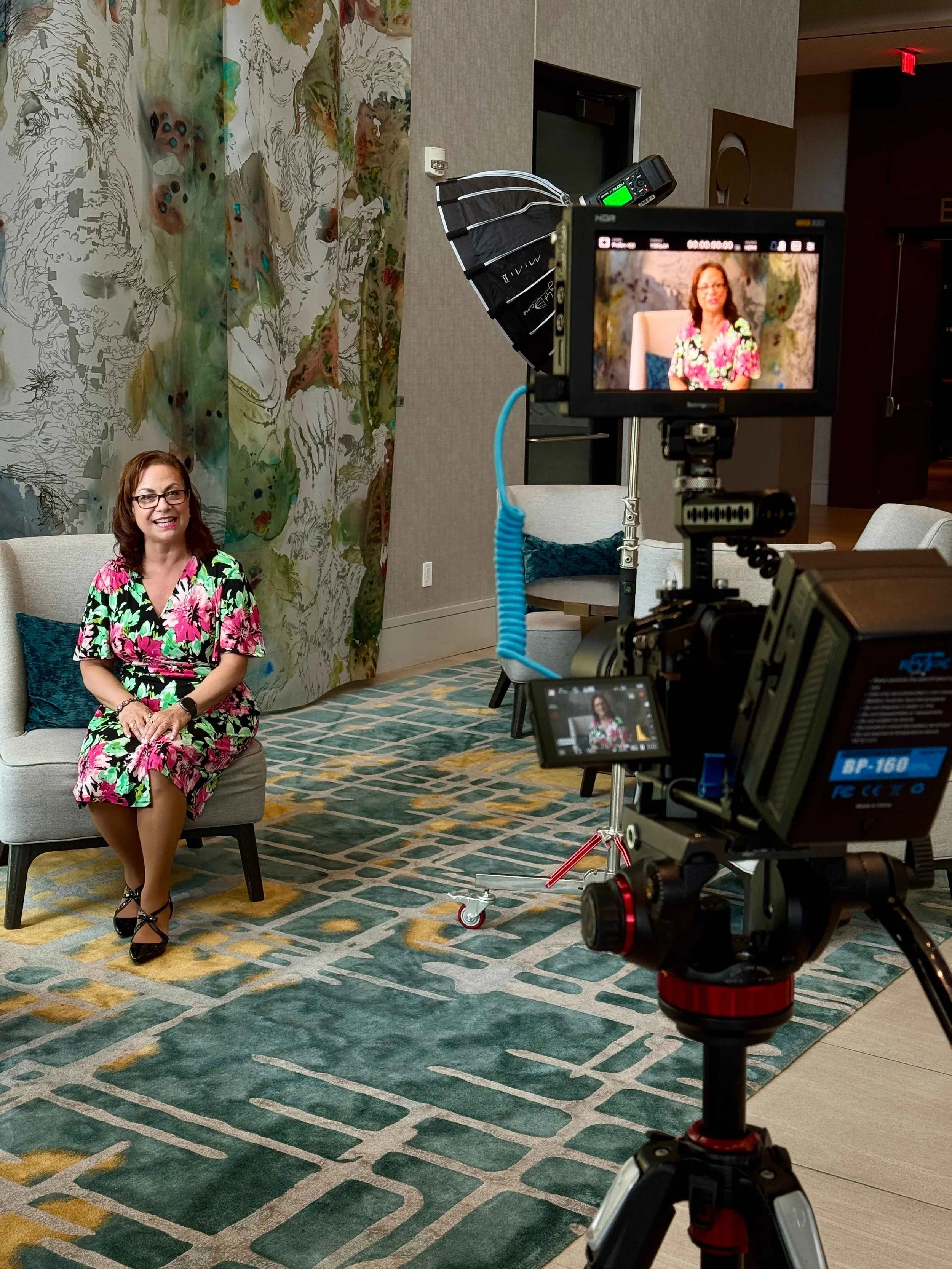 Professional video camera filming a female speaker at an industry conference