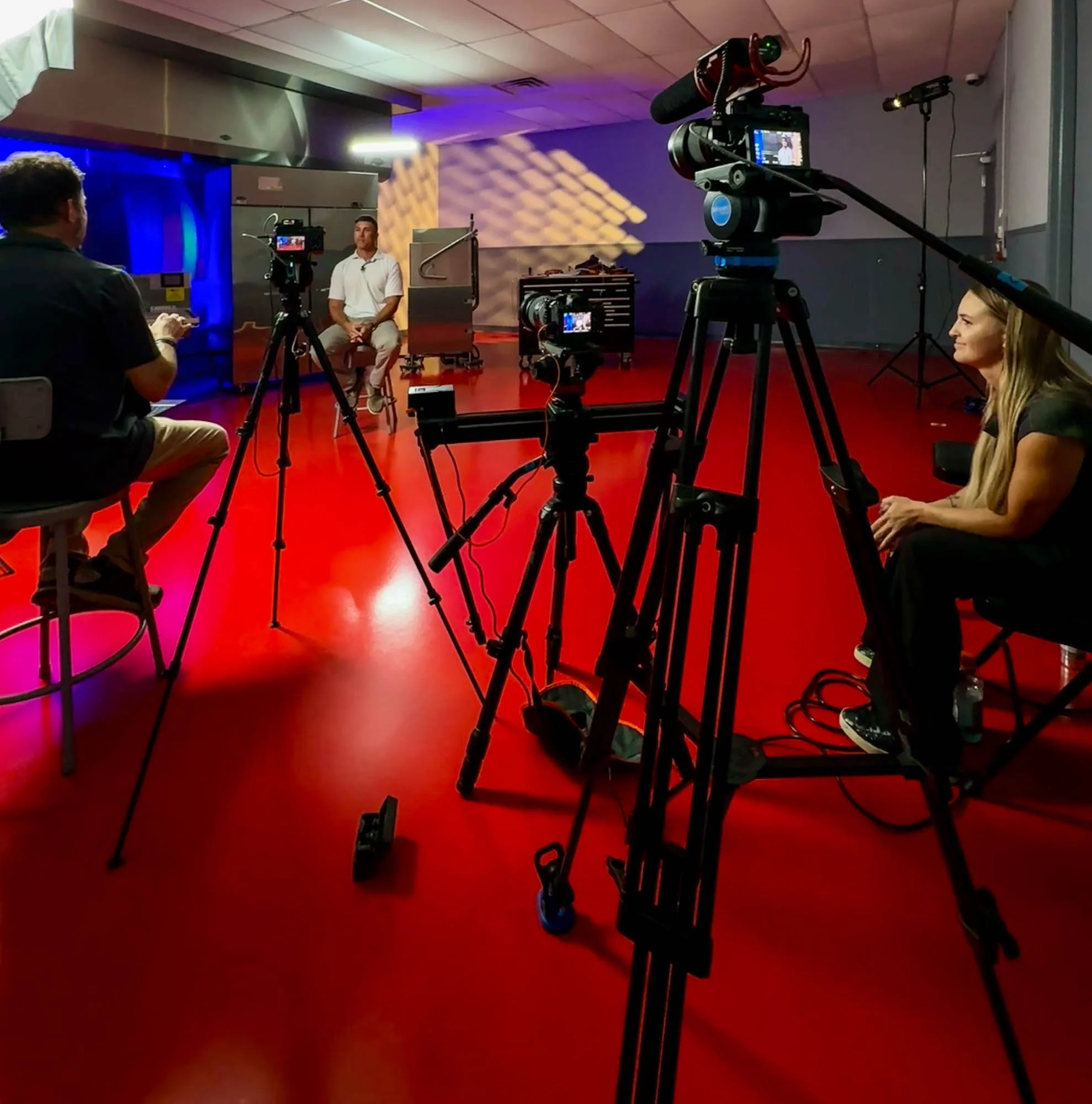 Multi-camera video production setup filming interviews and presentations at a professional industry event