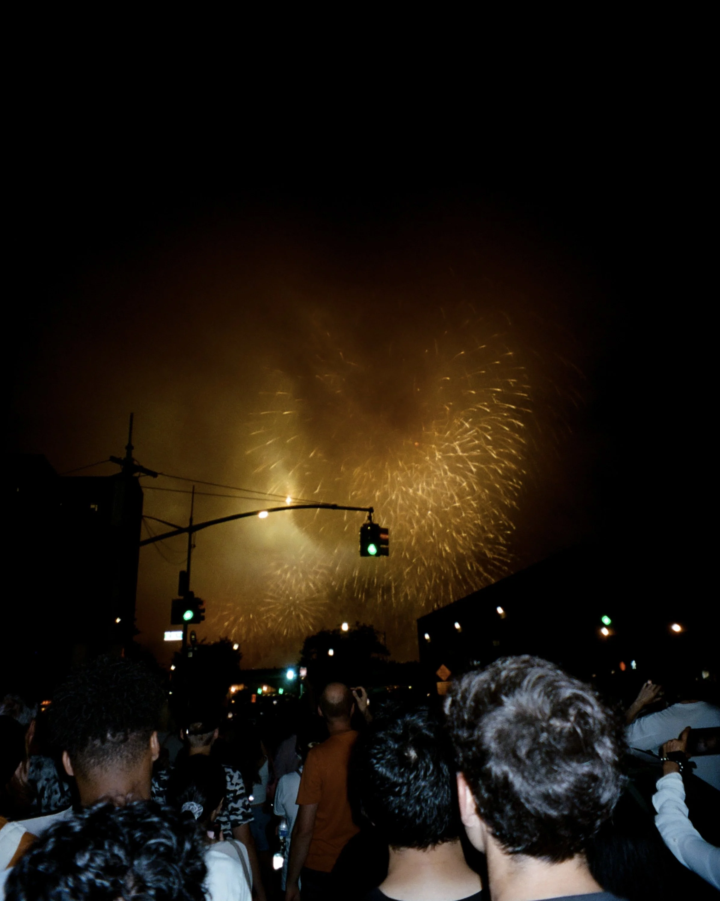 Flash photo of people gathered on the street to watch fireworks