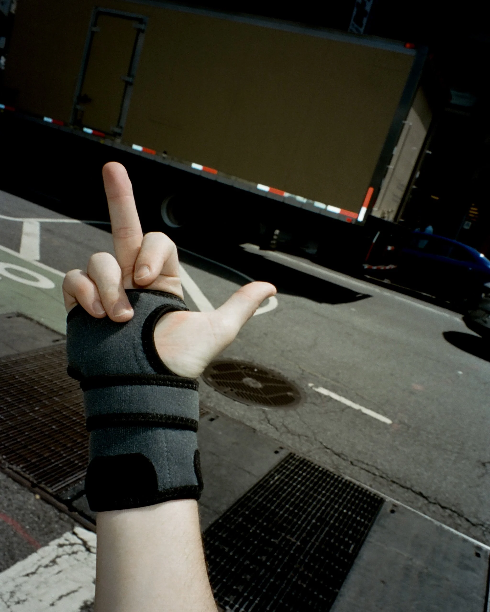Photo of someone wearing a wrist brace and giving the middle finger
