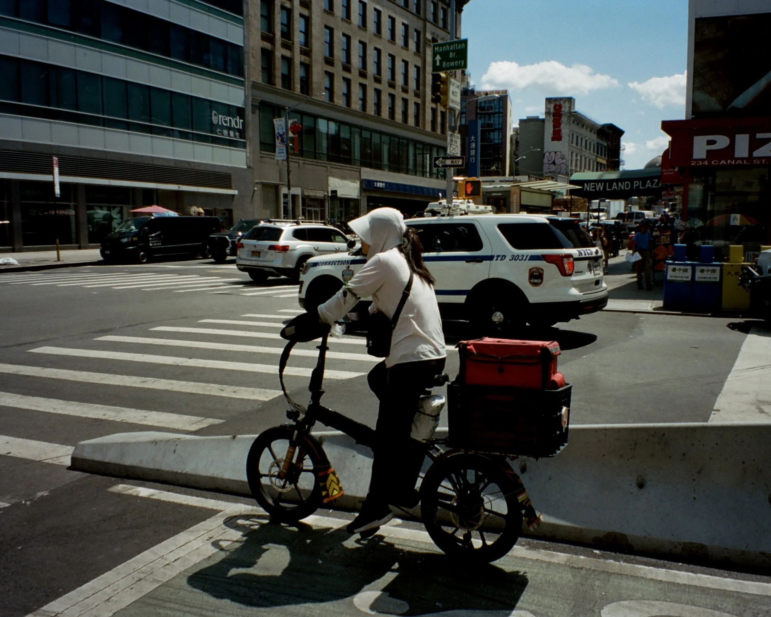 Photo of a woman on a delivery bike waiting at a stoplight