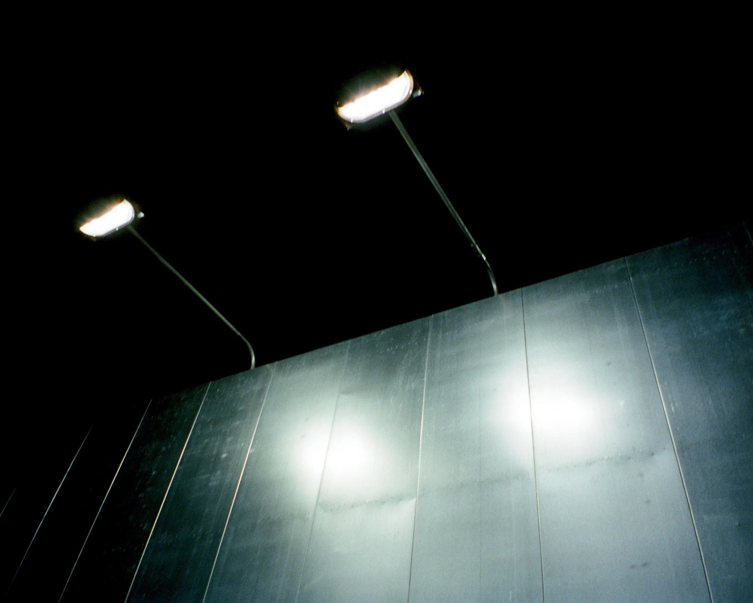 The reflection of lights on an empty metal billboard