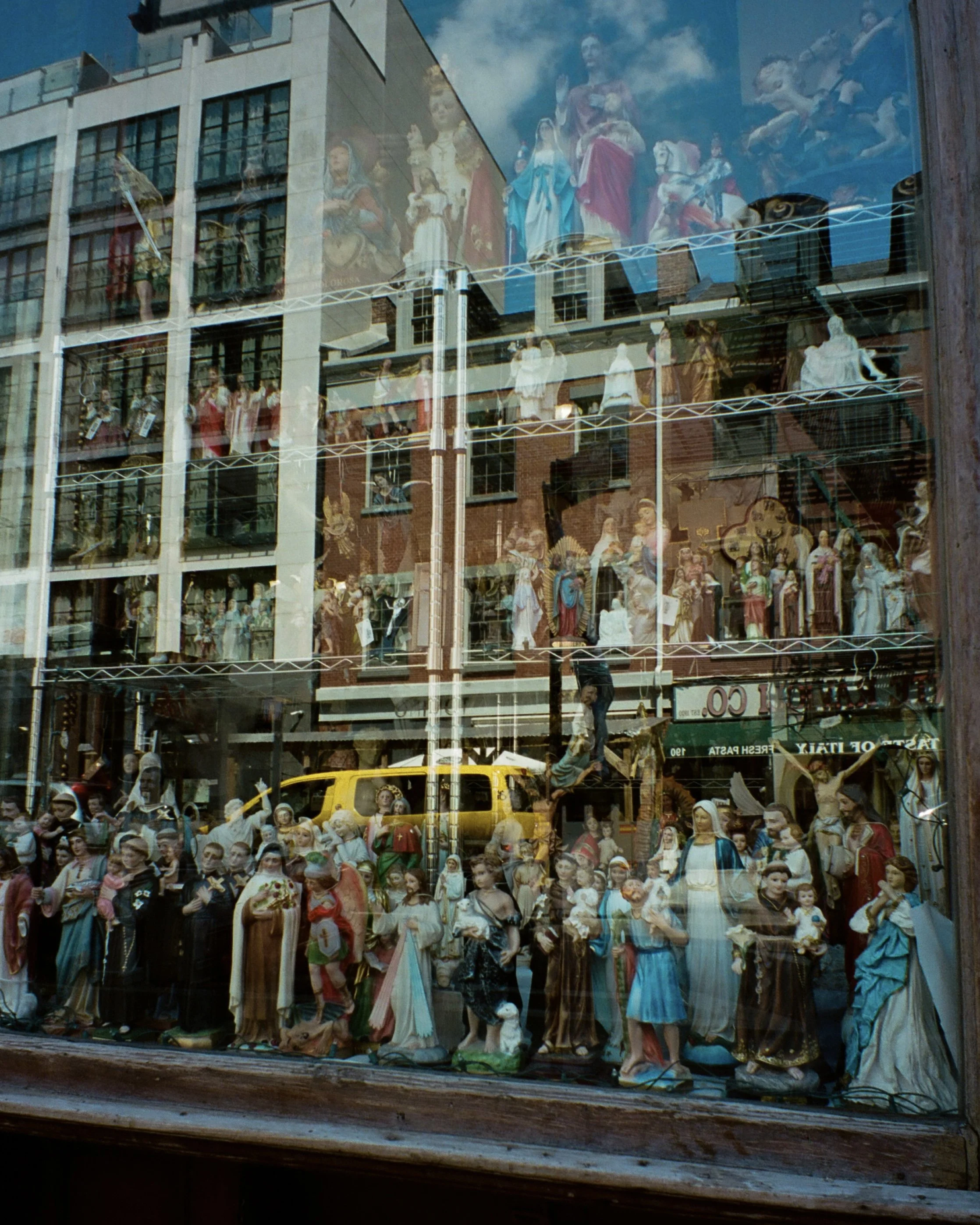 Photo of figurines in the window with a reflection of buildings in front