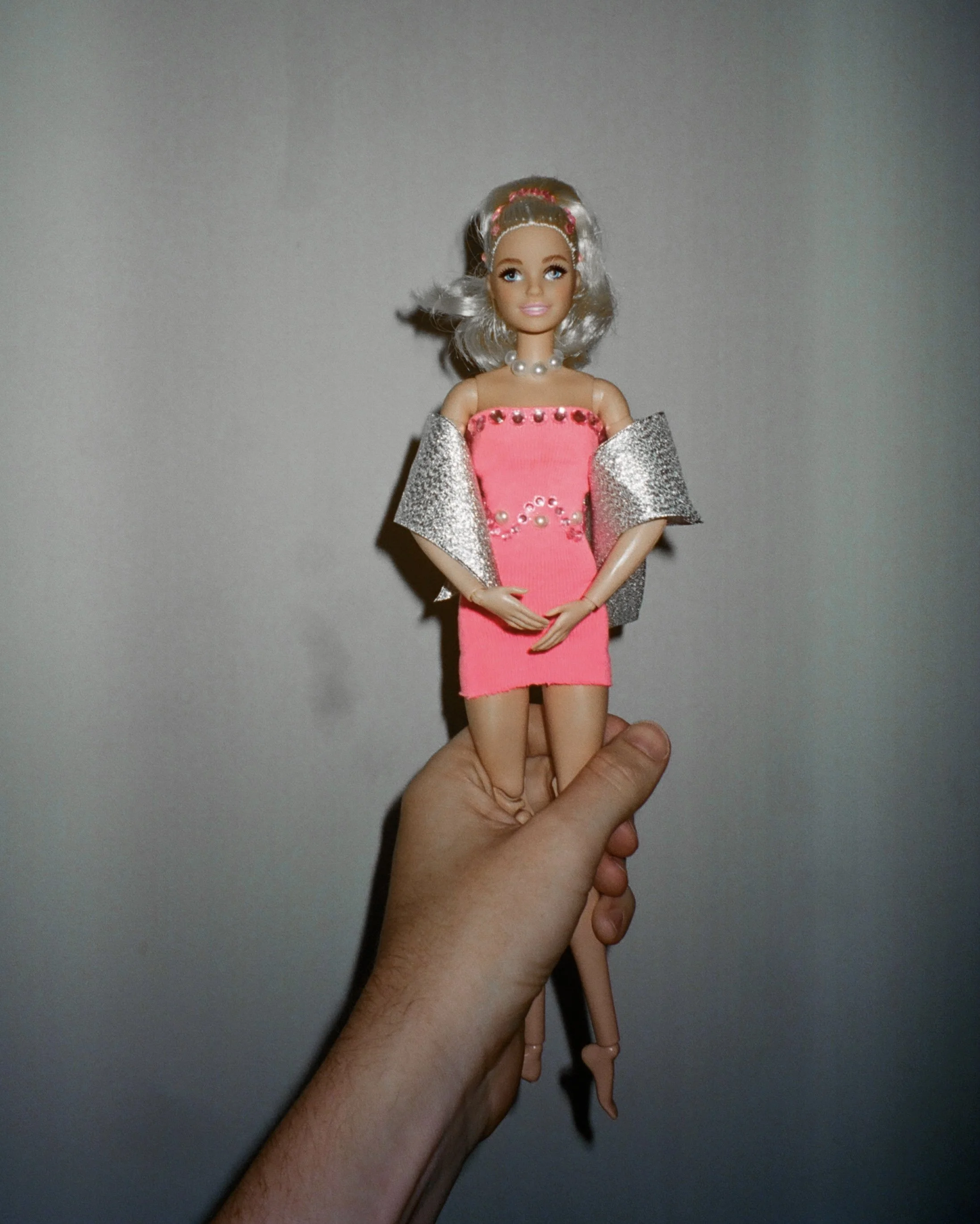 Photo of a Barbie wearing a hot pink dress with sequins and a shawl