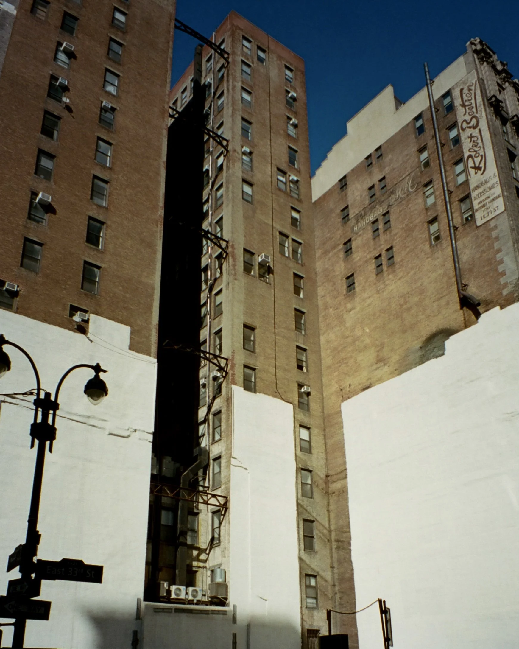 Photo of white paint covering the bottom half of brick buildings