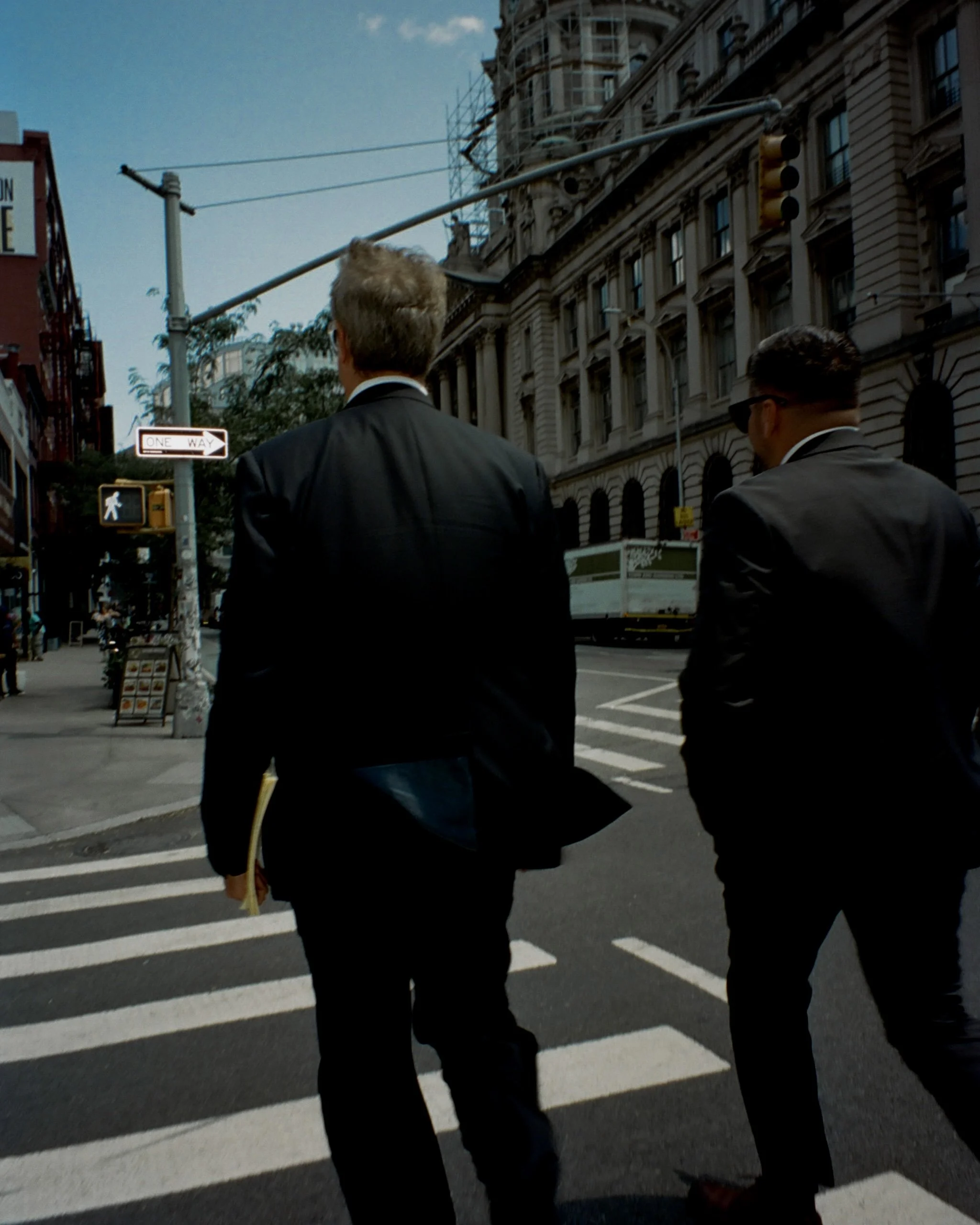 Image of two men in suits crossing the street from behind