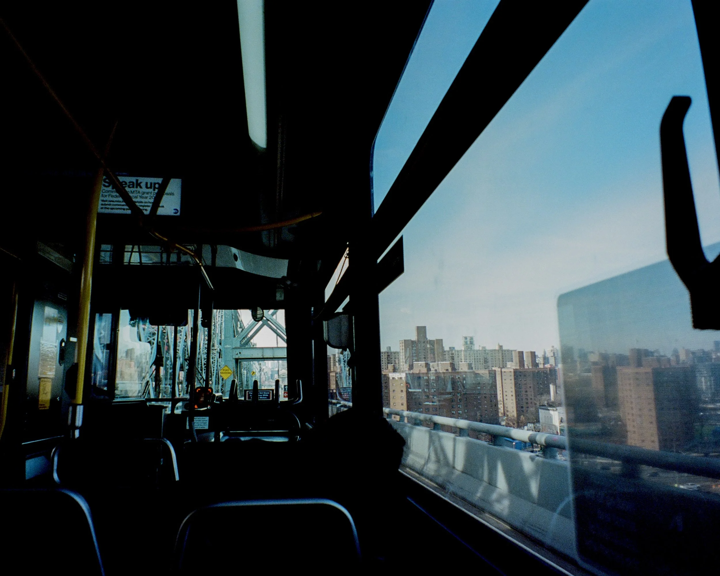 A view from inside of a bus and the city traveling over a bridge