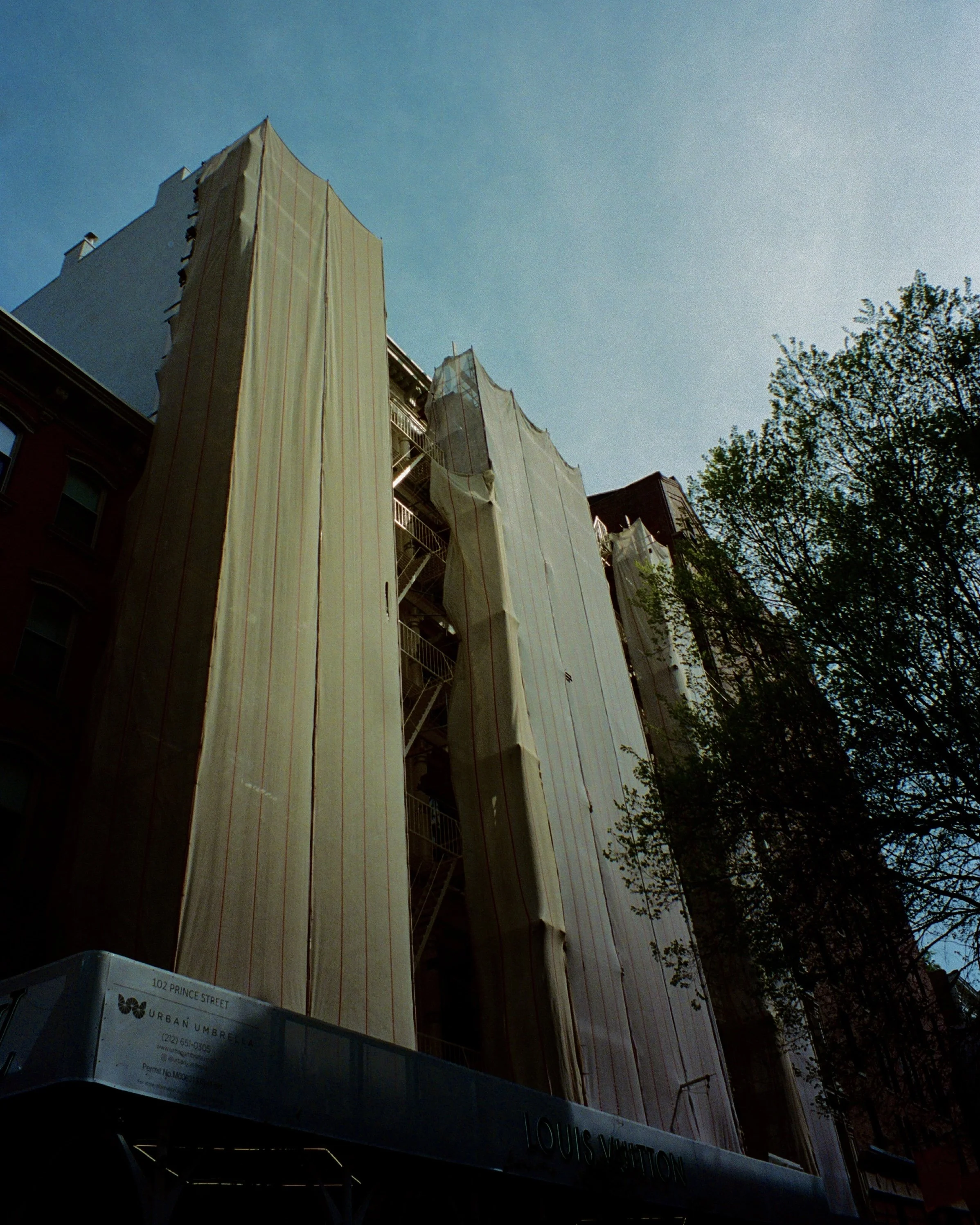 A building draped in construction tarp