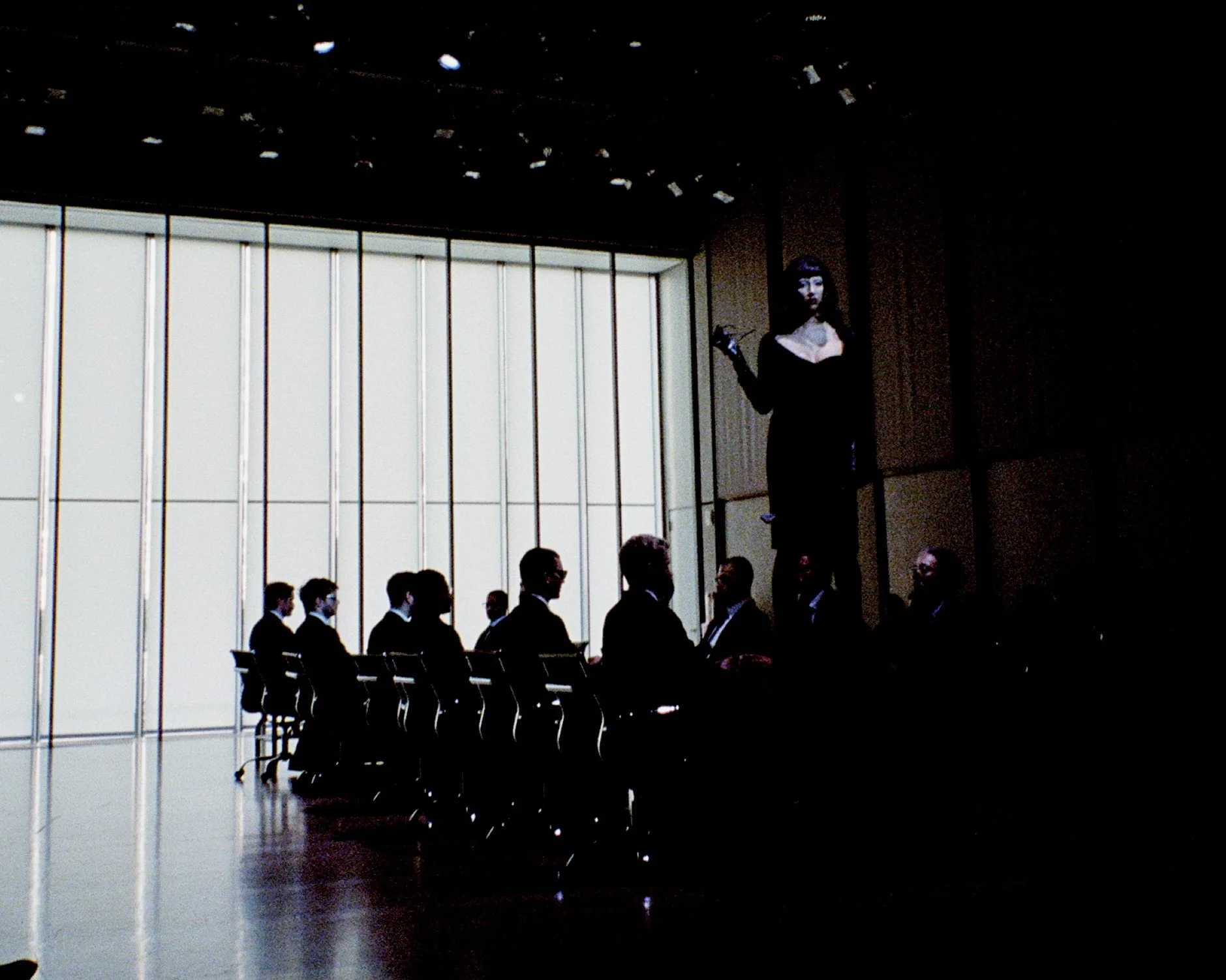 A woman standing on top of a table at a fake business meeting