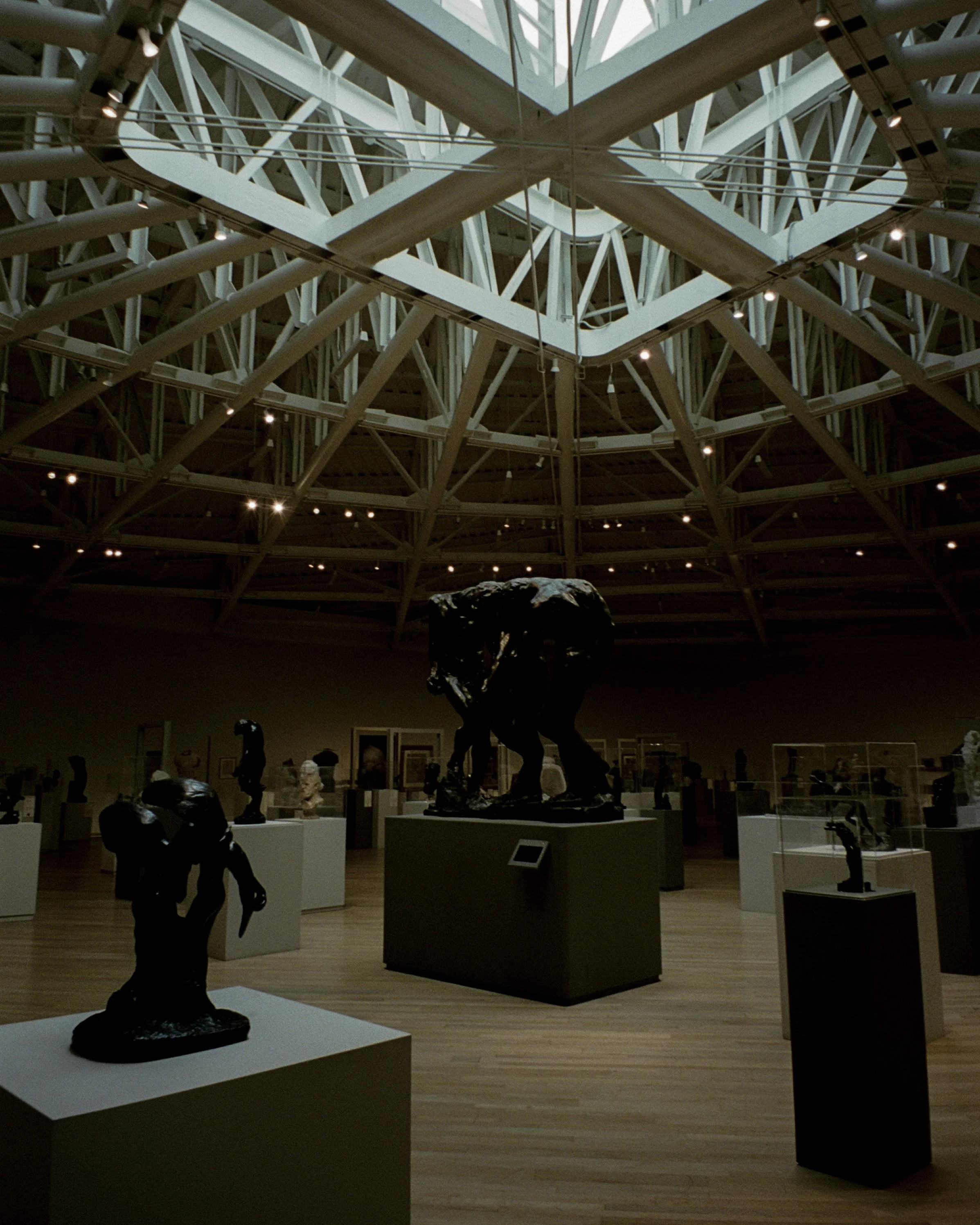 A collection of brass sculptures at a museum under a skylight