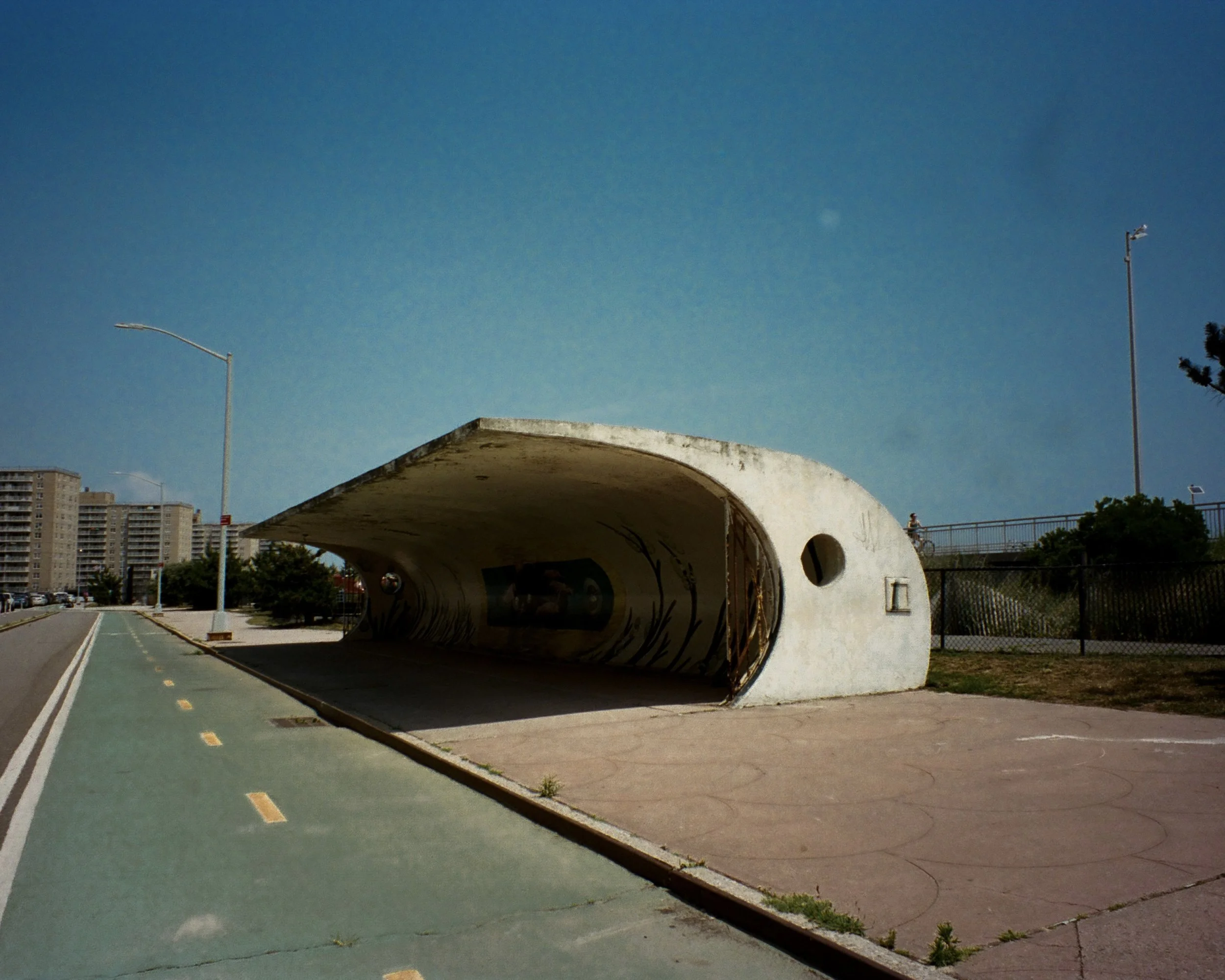 photo of a brutalist bus stop in the shape of a wave near the beach