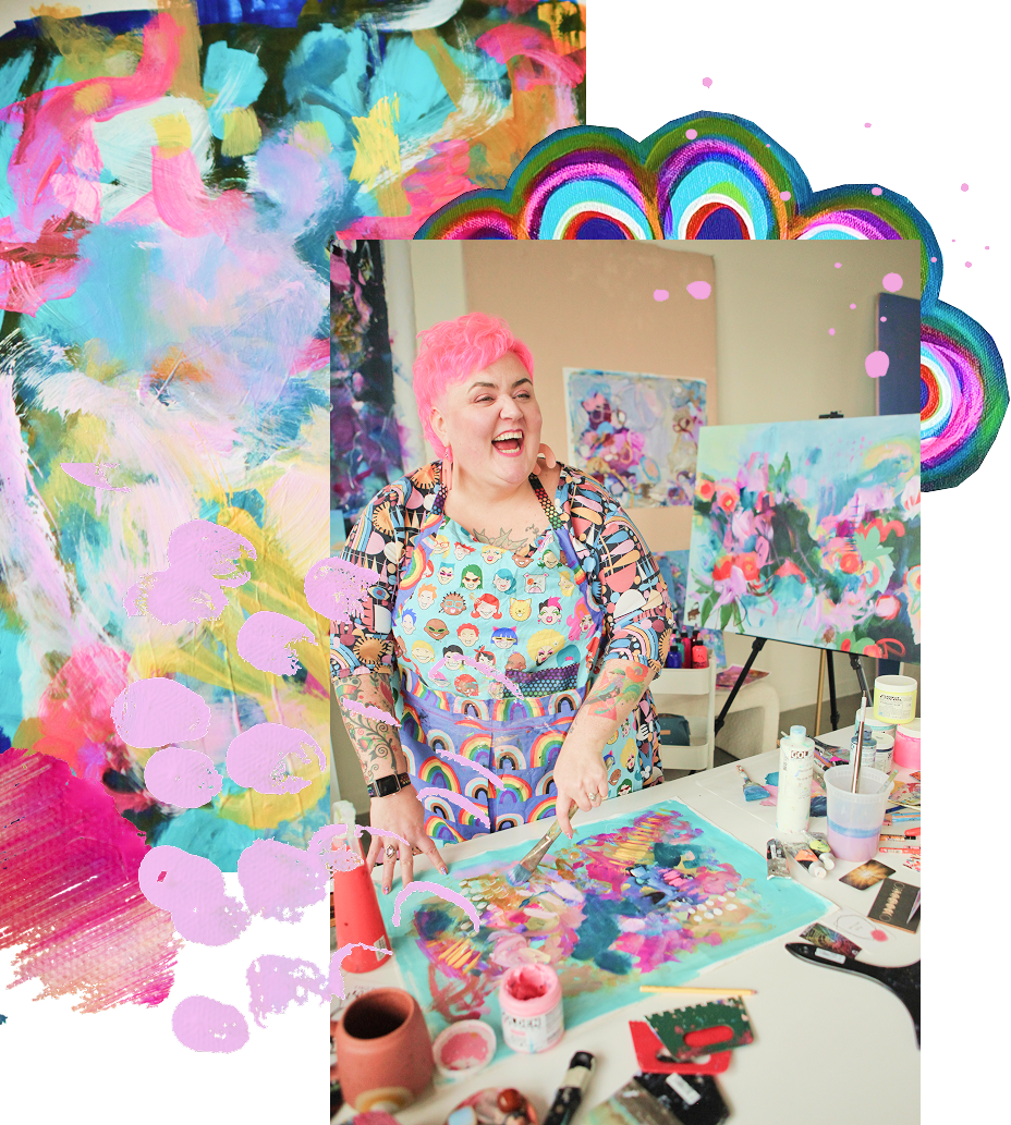 Becky Joan Springer with short pink hair and colorful clothing is smiling and laughing while working on a vibrant abstract painting at her art studio. The studio has colorful paintings and art supplies on the table and walls.