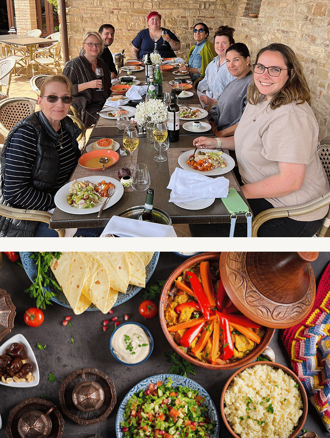Group of women enjoying a meal at an outdoor restaurant, with a table set with plates of food, wine, and a centerpiece, and traditional Mexican dishes including salsa, vegetables, and tortillas.