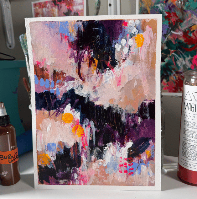 Abstract expressionist painting with pink, purple, black, white, and yellow colors, displayed on an easel.
