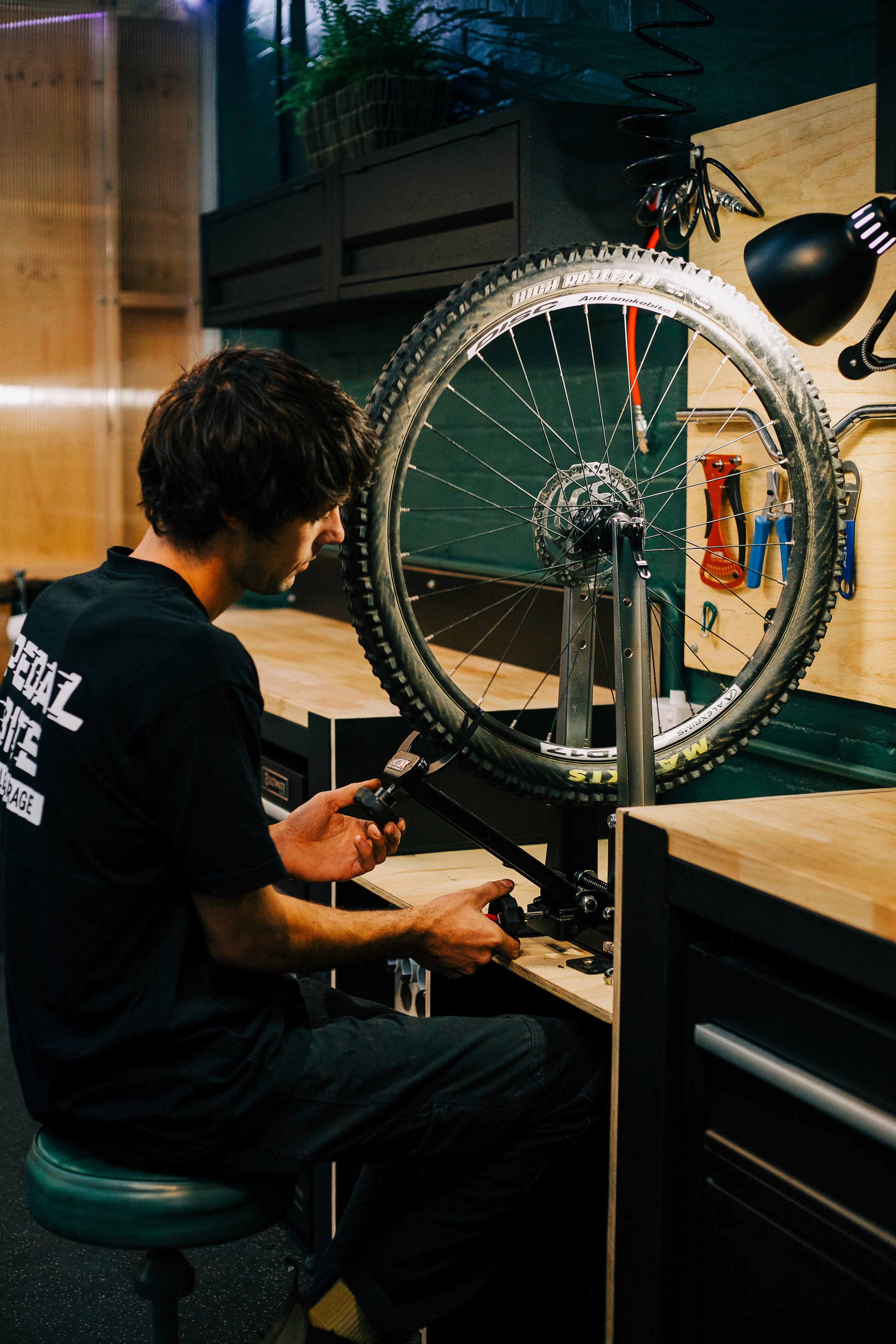 A person working on a mountain bike in a workshop, fixing or assembling it.
