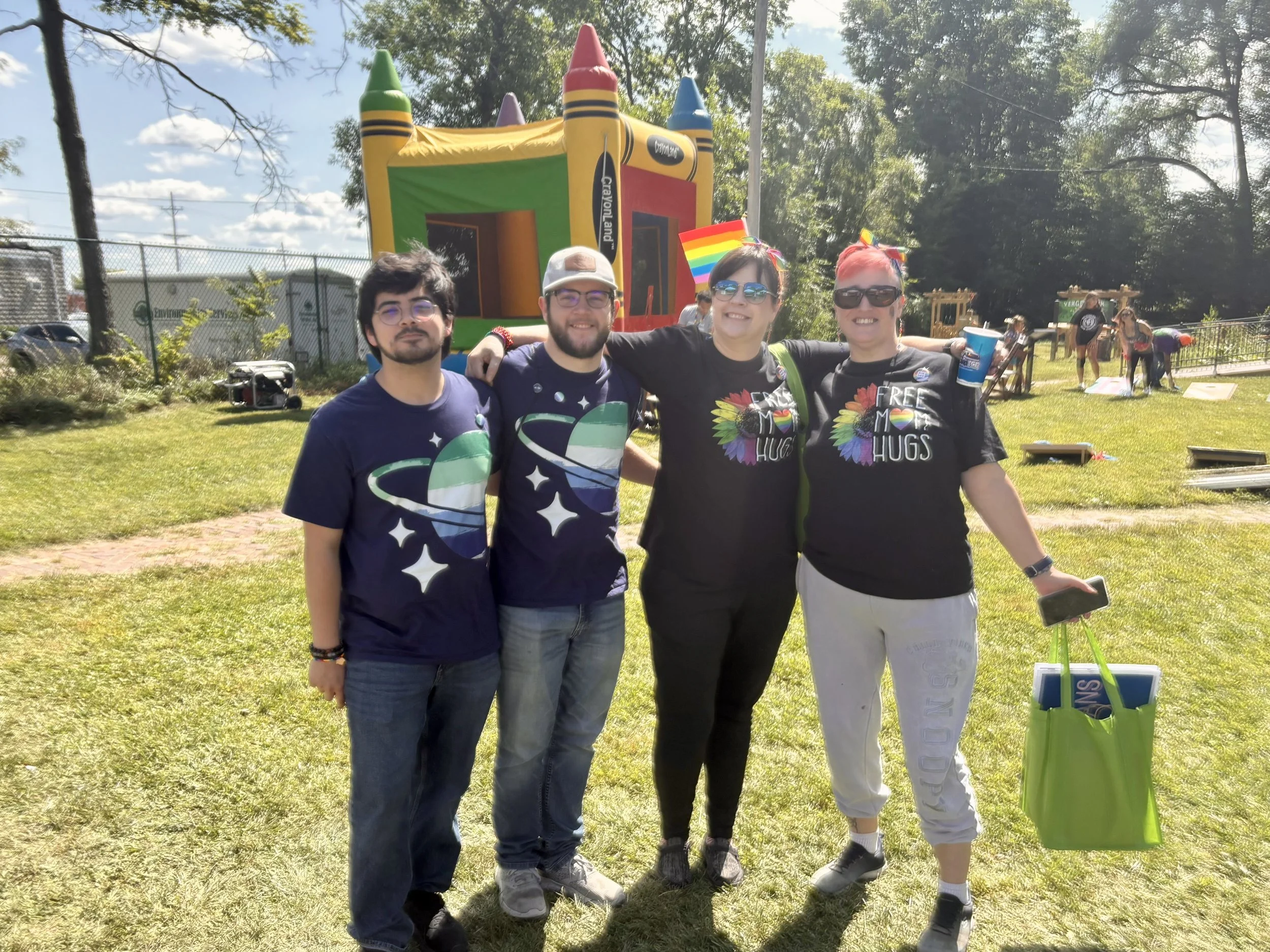 Four people enjoying pride, posing for camera