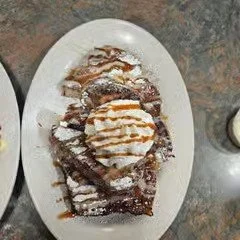 Plate of Belgian waffles topped with whipped cream and drizzled with caramel syrup