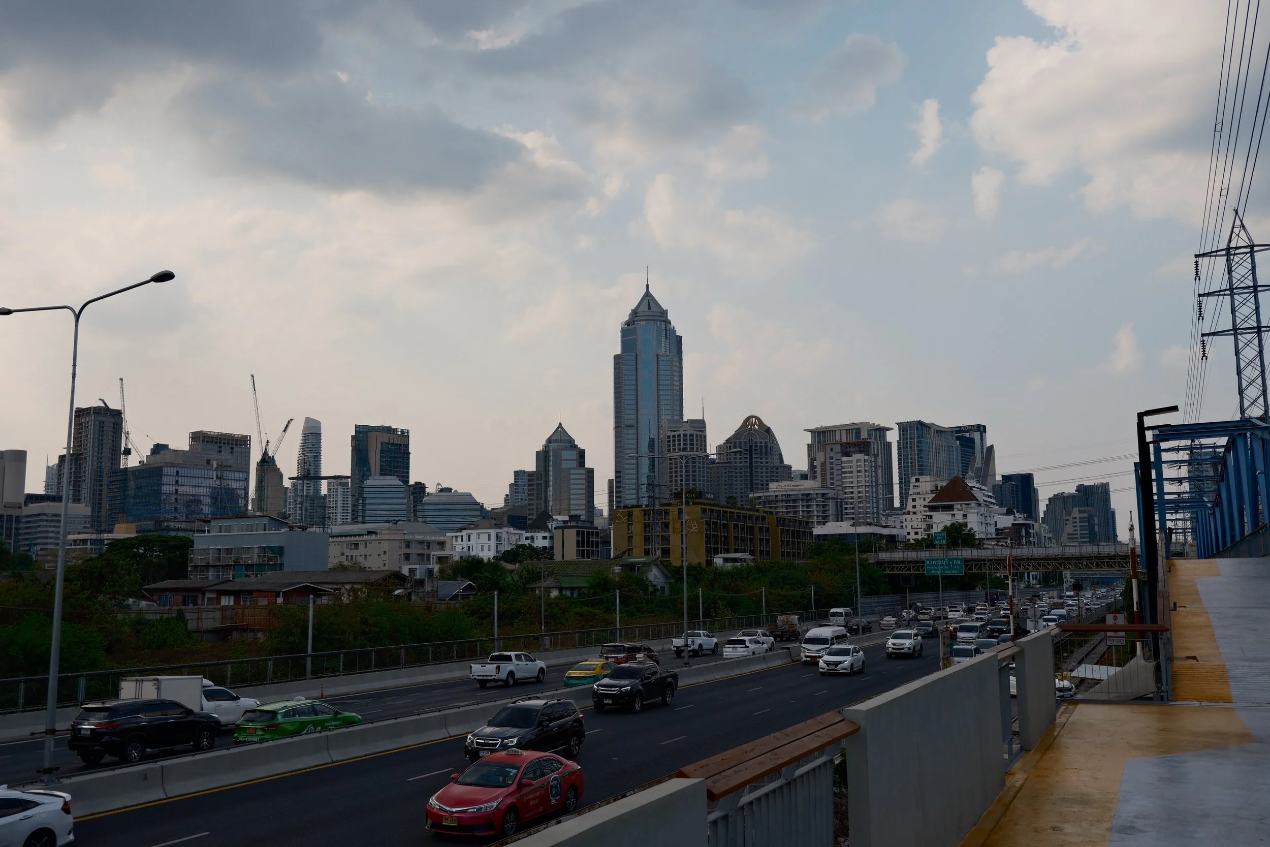 Skyline of a city with tall skyscrapers and a busy highway with cars.