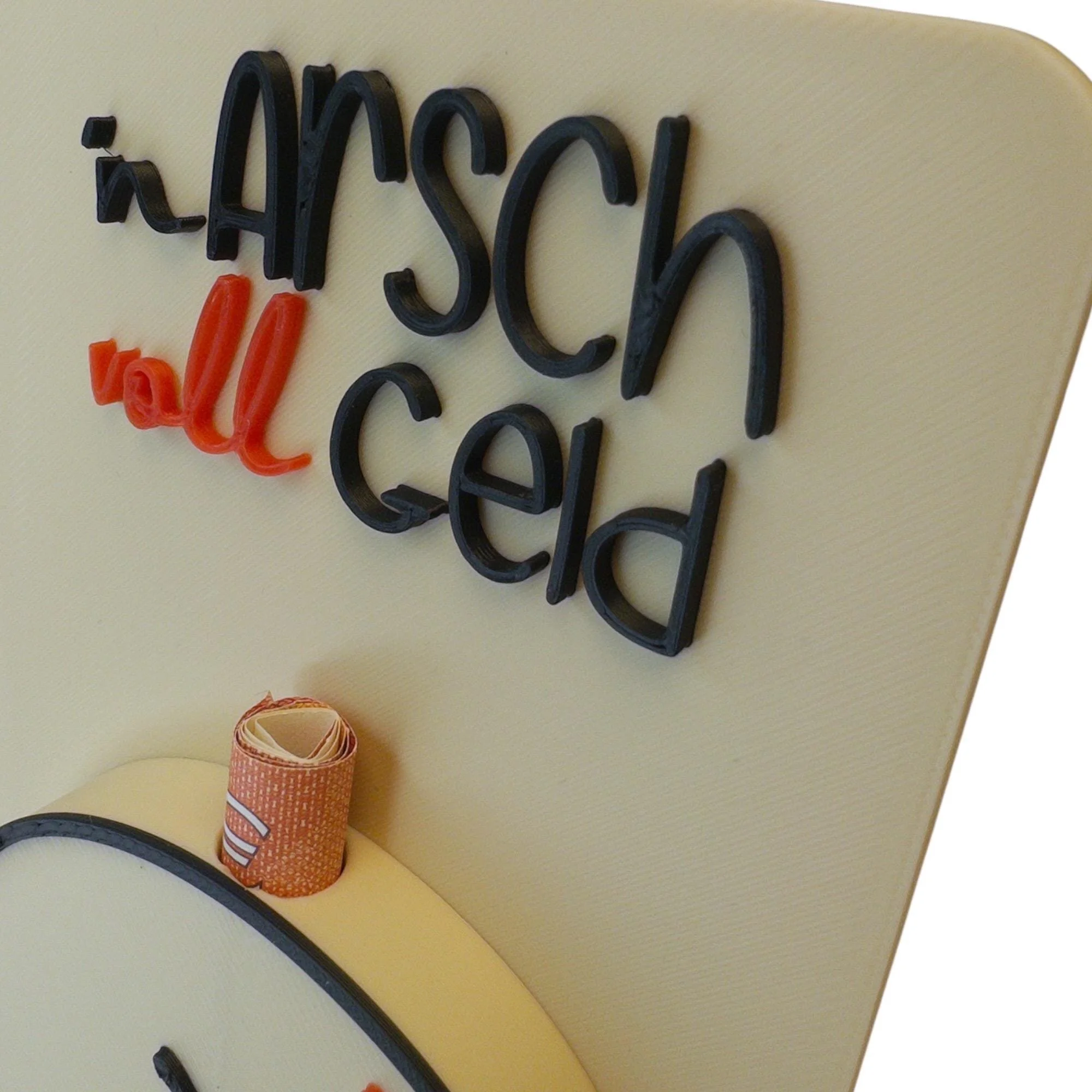 Detailansicht der beigen Karte mit erhabenem Schriftzug n Arsch voll Geld und sichtbarem Geldscheinhalter am unteren Bildrand.