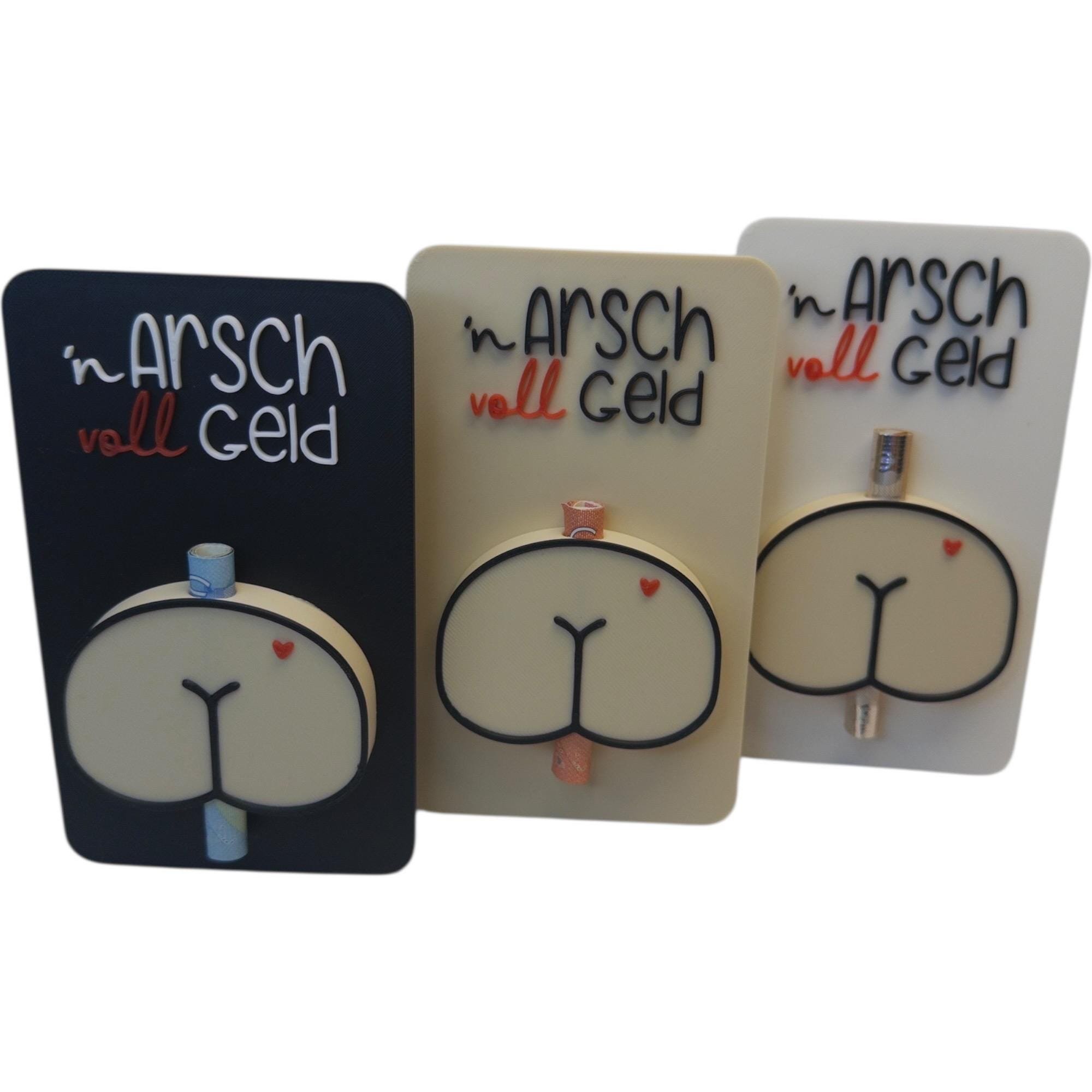 Geldscheinhalter in Schwarz, Beige und Weiß nebeneinander gestellt, jeweils mit Schriftzug n Arsch voll Geld und Po-Motiv für gerollte Scheine.