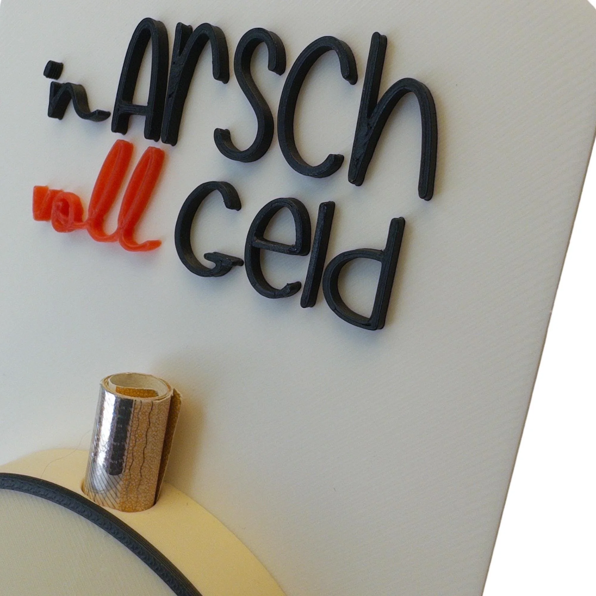 Nahaufnahme der hellen Karte mit Schriftzug n Arsch voll Geld und seitlich sichtbarem Schlitz für einen gerollten Geldschein.