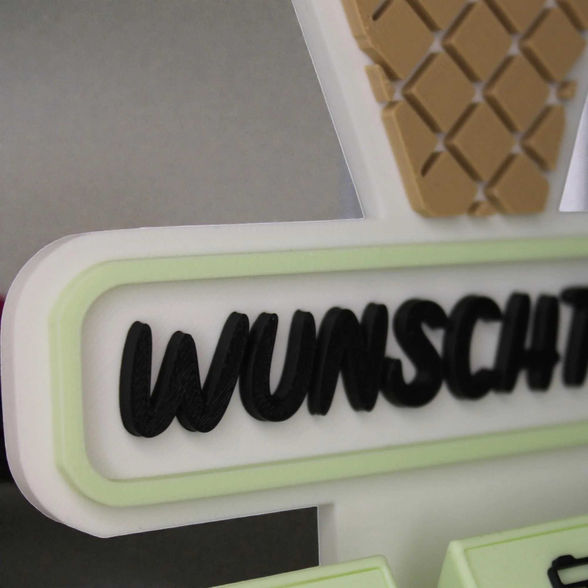 Detailansicht des Eistüten-Aufstellers mit erhabenem Wunschtext, pastellgrünem Rand und Waffelstruktur im oberen Bereich.