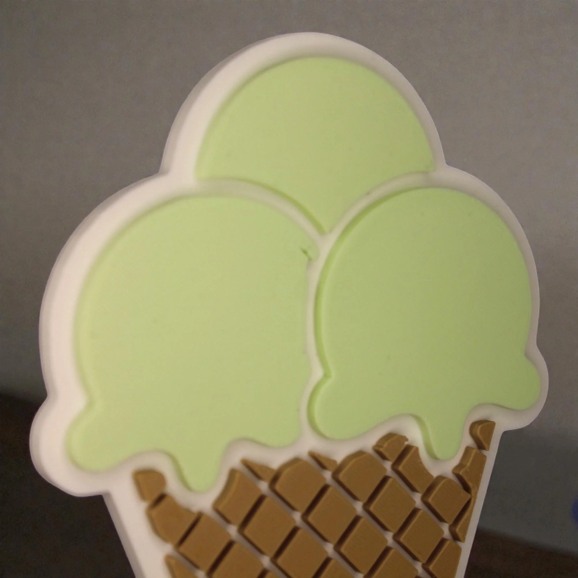 Detail des Eistütenkopfs mit drei pastellgrünen Kugeln und Waffelmuster als dekorativer oberer Teil des Aufstellers.