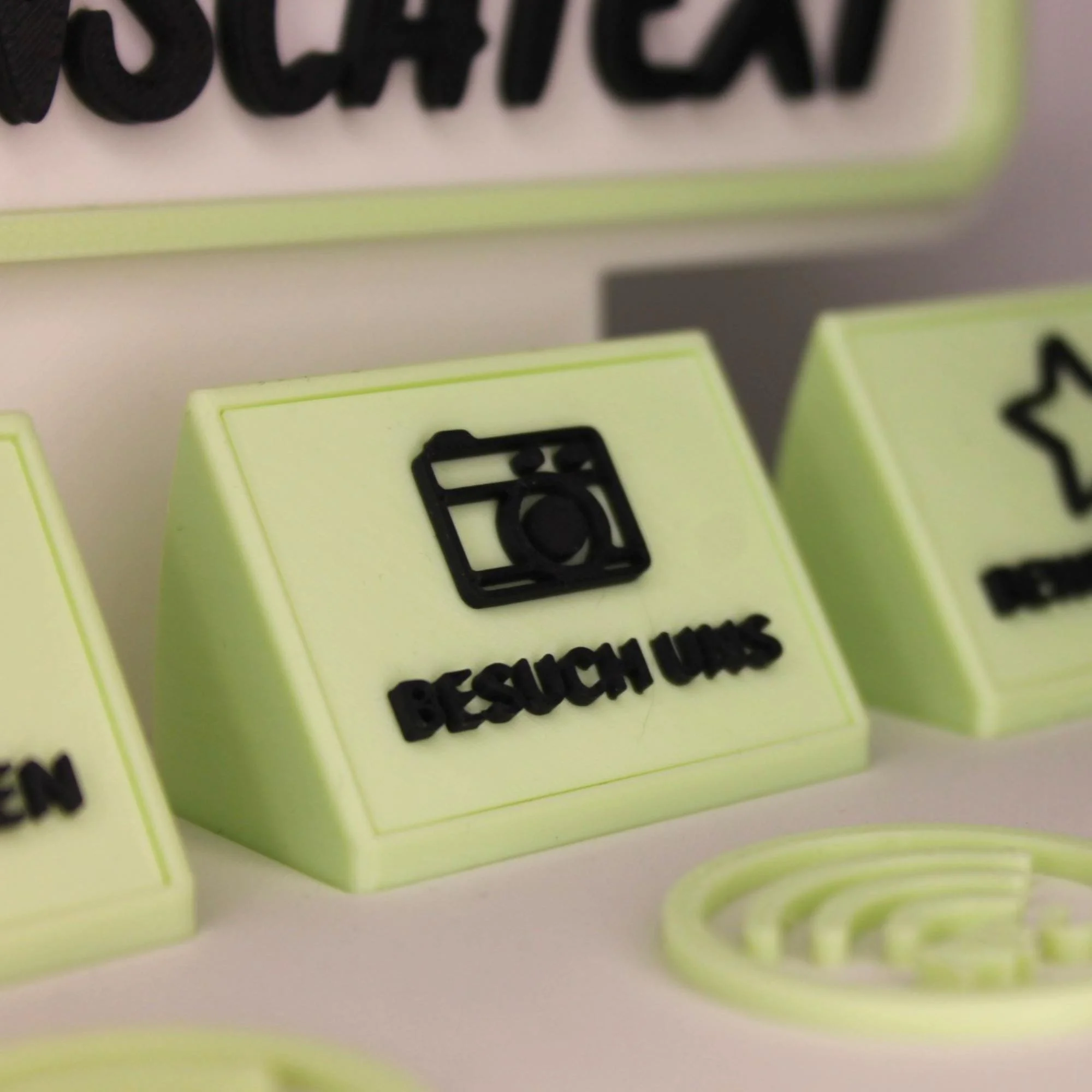 Detailansicht der Inlays am NFC Eistüten-Aufsteller mit Beschriftungen wie Besuch mich und Kontakt auf pastellgrüner Basis.