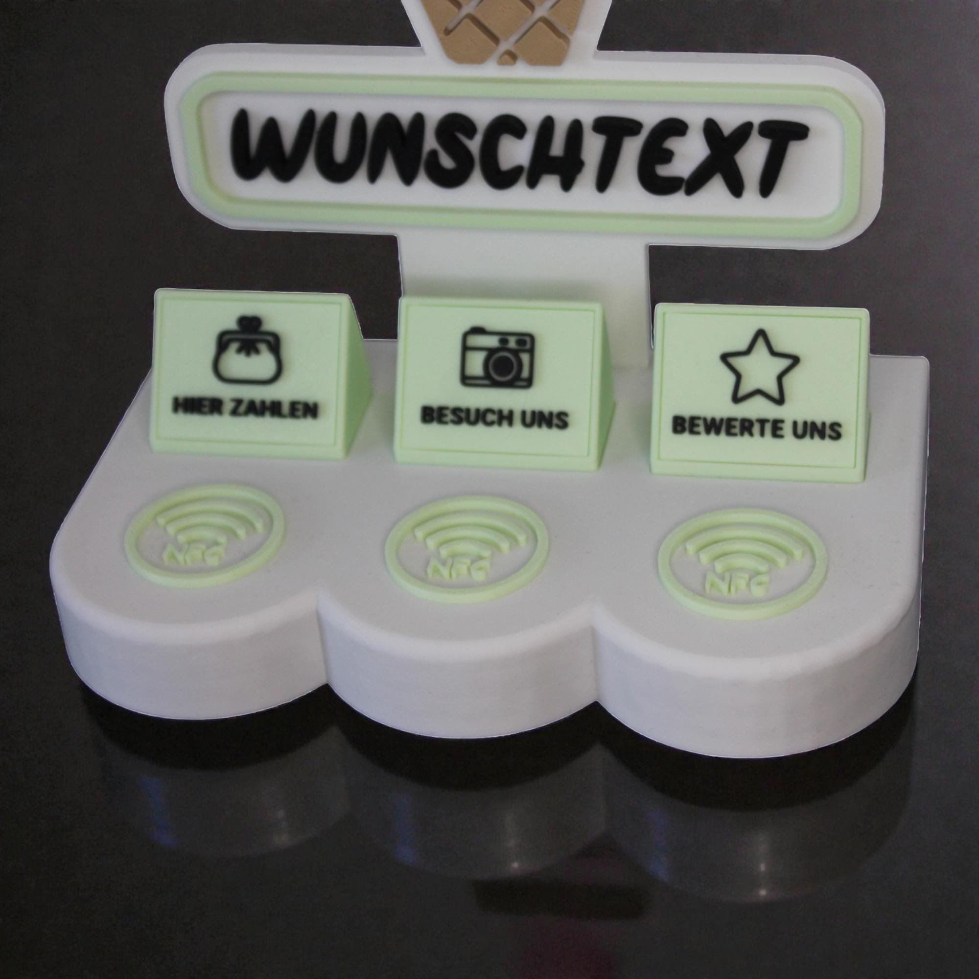 Unterer Bereich des Aufstellers mit Wunschtext, drei beschrifteten NFC-Feldern und pastellgrünen Standfüßen auf dunklem Hintergrund.