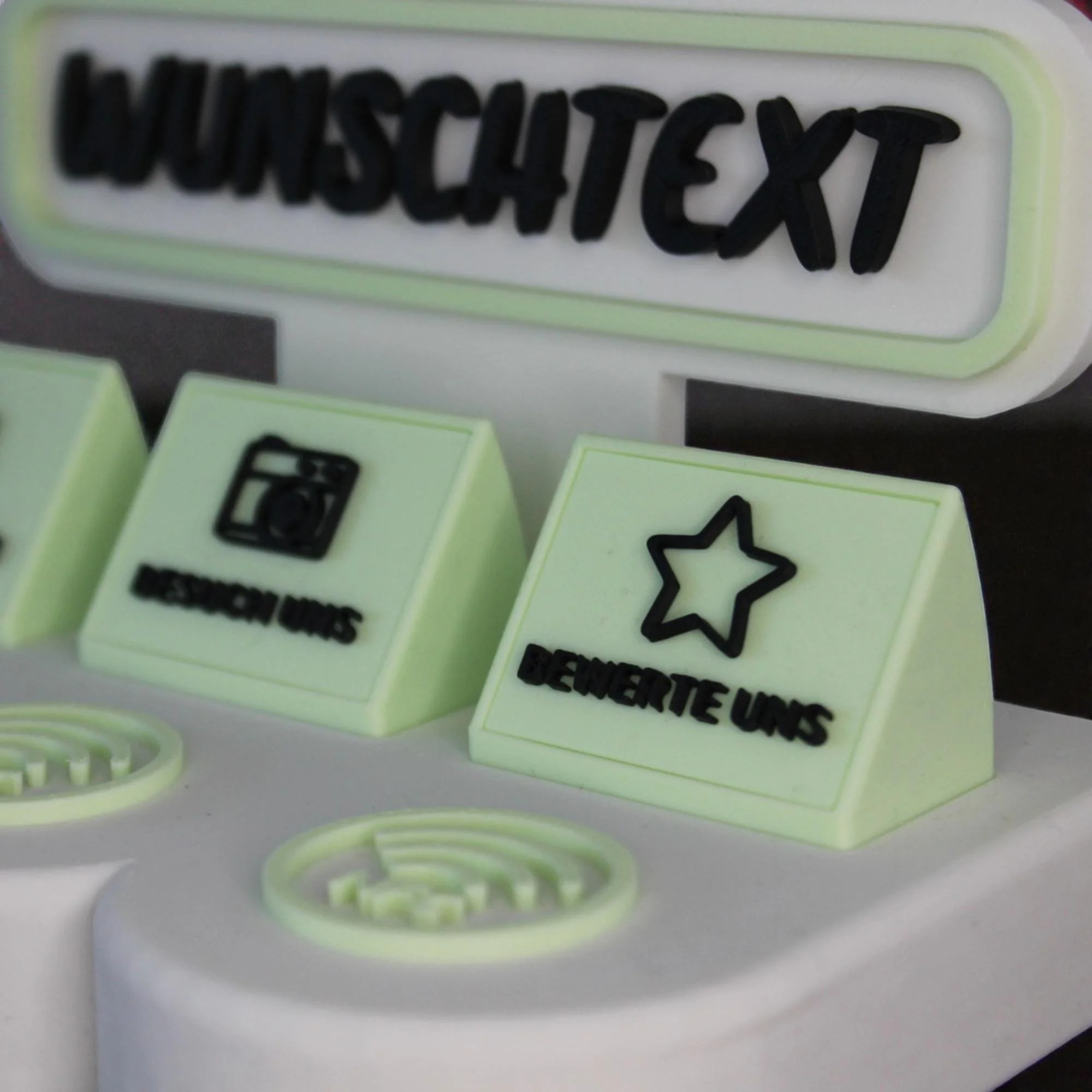 Schräge Nahaufnahme des Aufstellers mit erhabenem Wunschtext, Stern-Inlay und runder NFC-Fläche in Pastellgrün und Weiß.