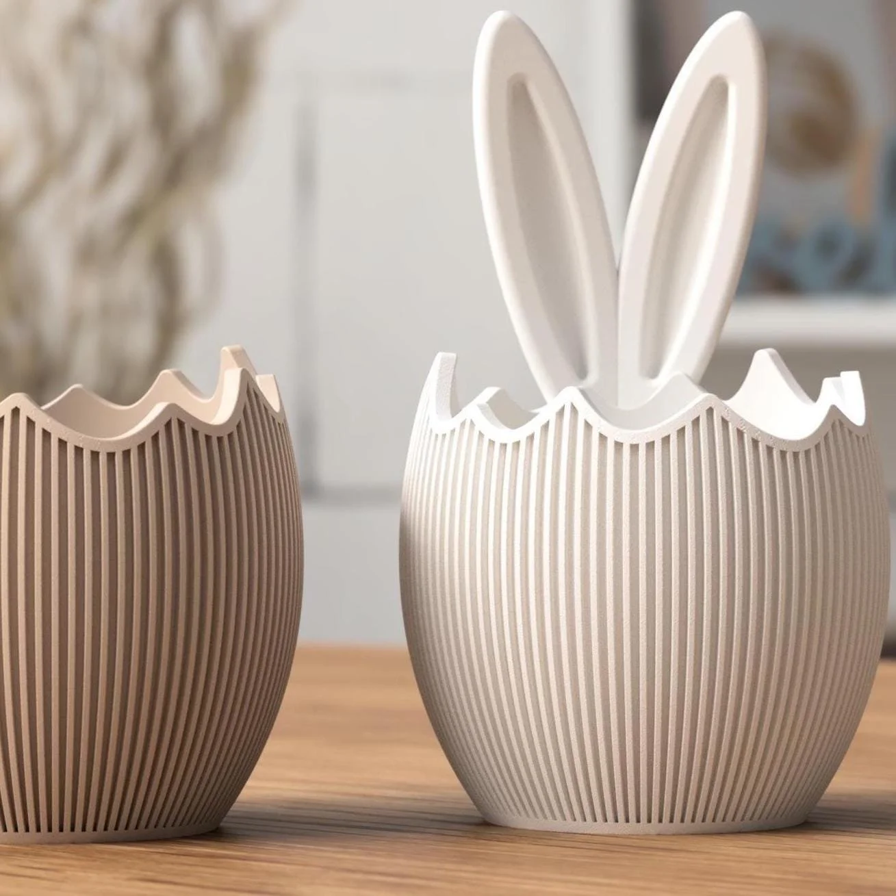 Osterschale 2er Set in Beige mit aufgebrochener Eierschalenform, eine Schale schlicht, die zweite mit Hasenohren, dekorativ auf Holz platziert.
