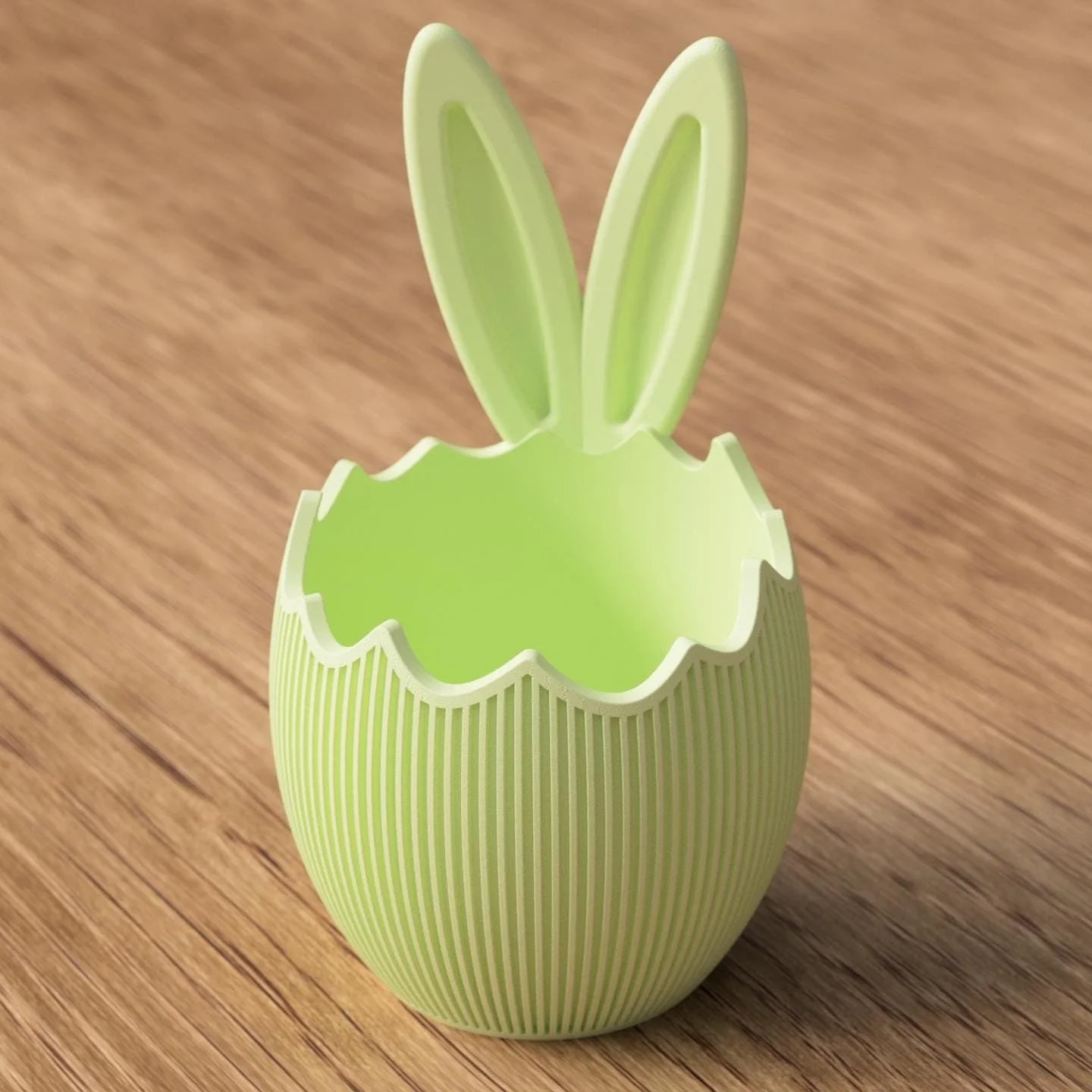 Osterschale mit Hasenohren in Hellgrün, gestaltet wie eine aufgebrochene Eierschale mit geriffelter Oberfläche auf Holzuntergrund.