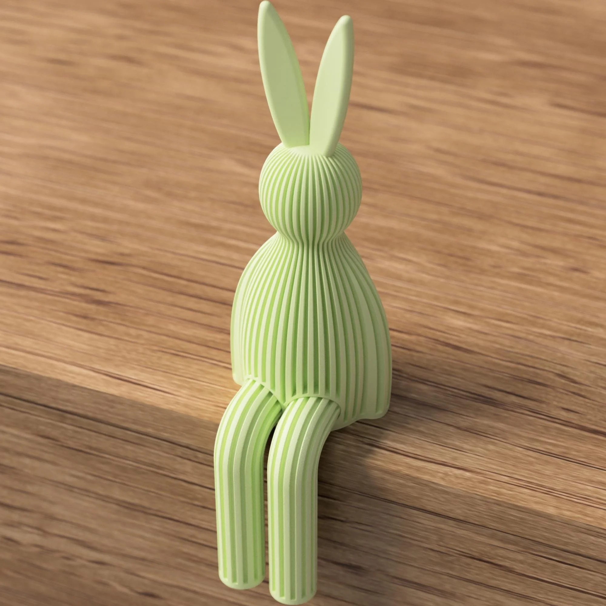 Hellgrüner Osterhase in gerippter Ausführung als sitzende Dekofigur mit hängenden Beinen auf warmer Holzoberfläche.