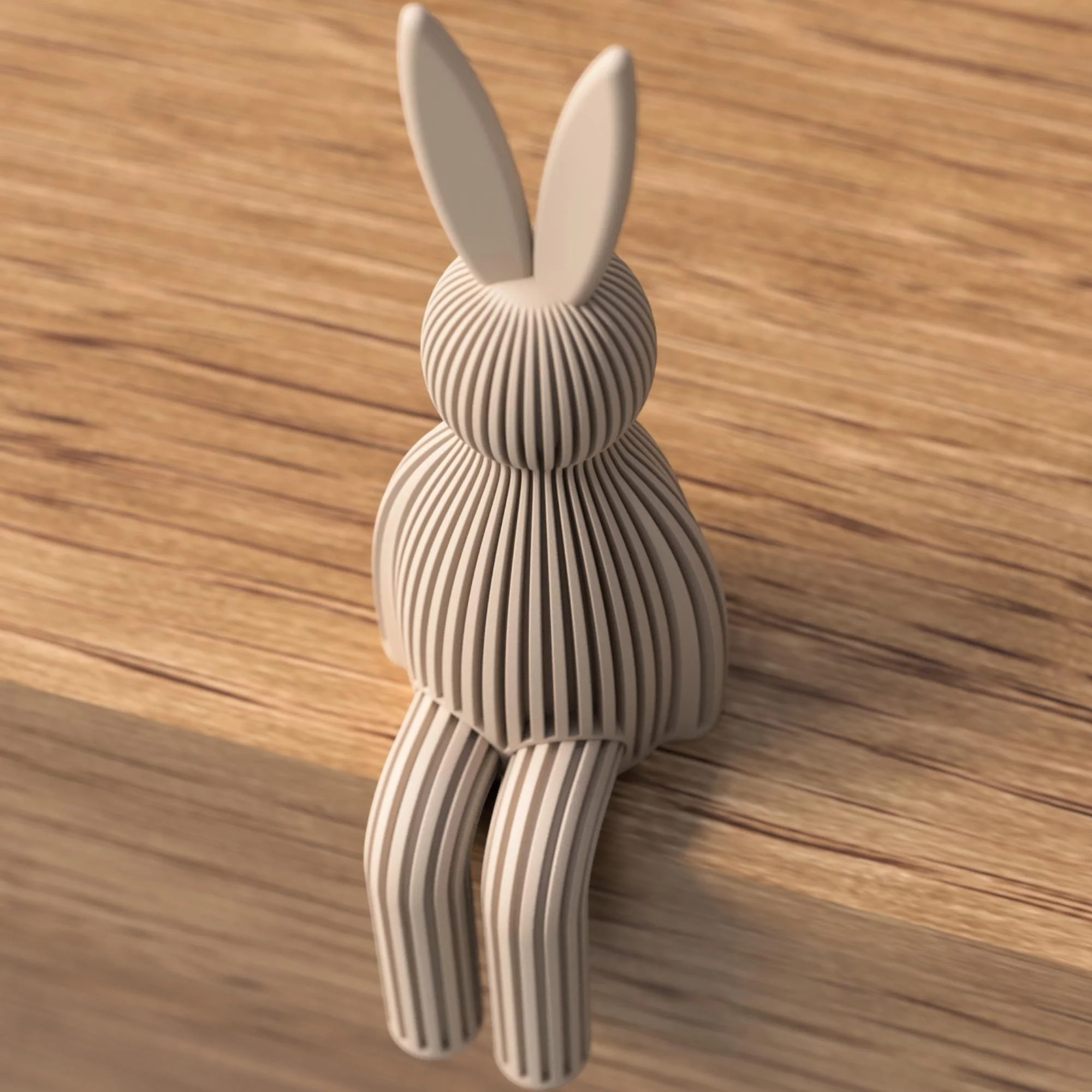 Taupefarbener Japandi Osterhase mit gerippter Struktur, seitlich sitzend auf Holz mit langen Ohren und hängenden Beinen.