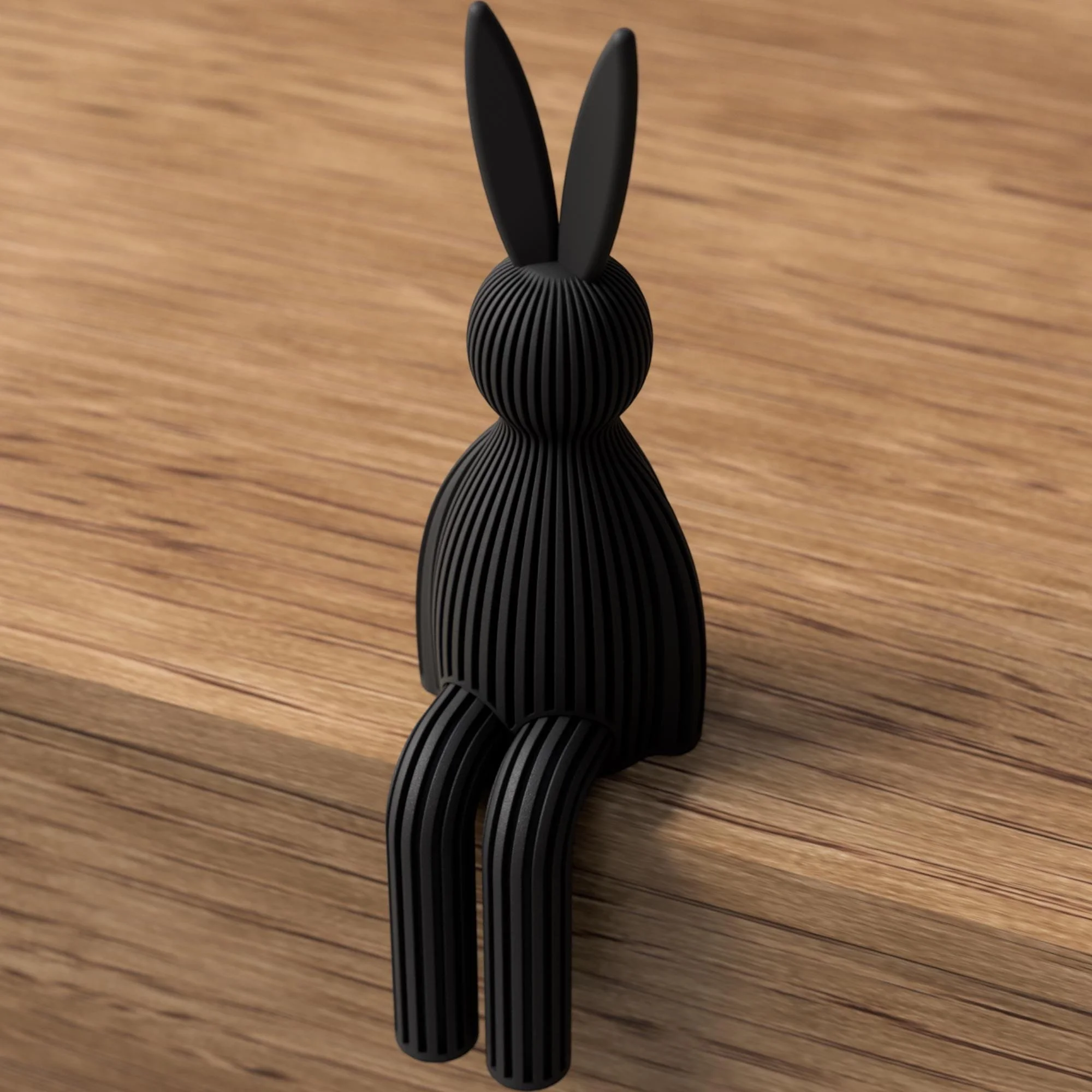 Schwarze Hasenfigur mit gerippter Struktur in Rückenansicht, sitzend auf Holz mit langen Ohren und geraden hängenden Beinen.