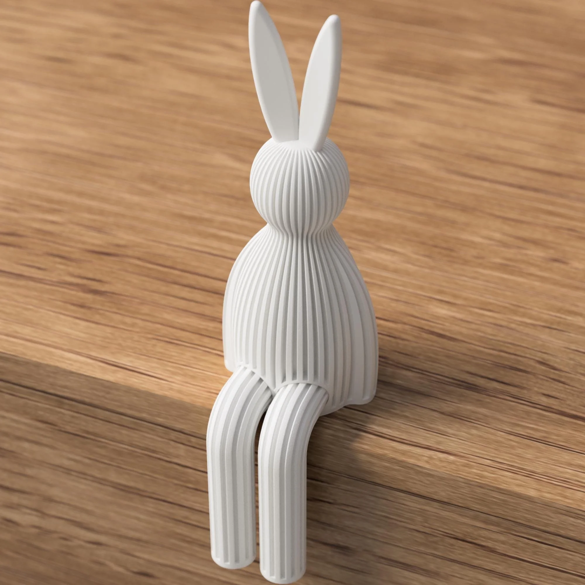 Weißer Osterhase in gerippter Ausführung, seitlich von hinten auf Holz gezeigt, mit langen Ohren und hängenden Beinen.