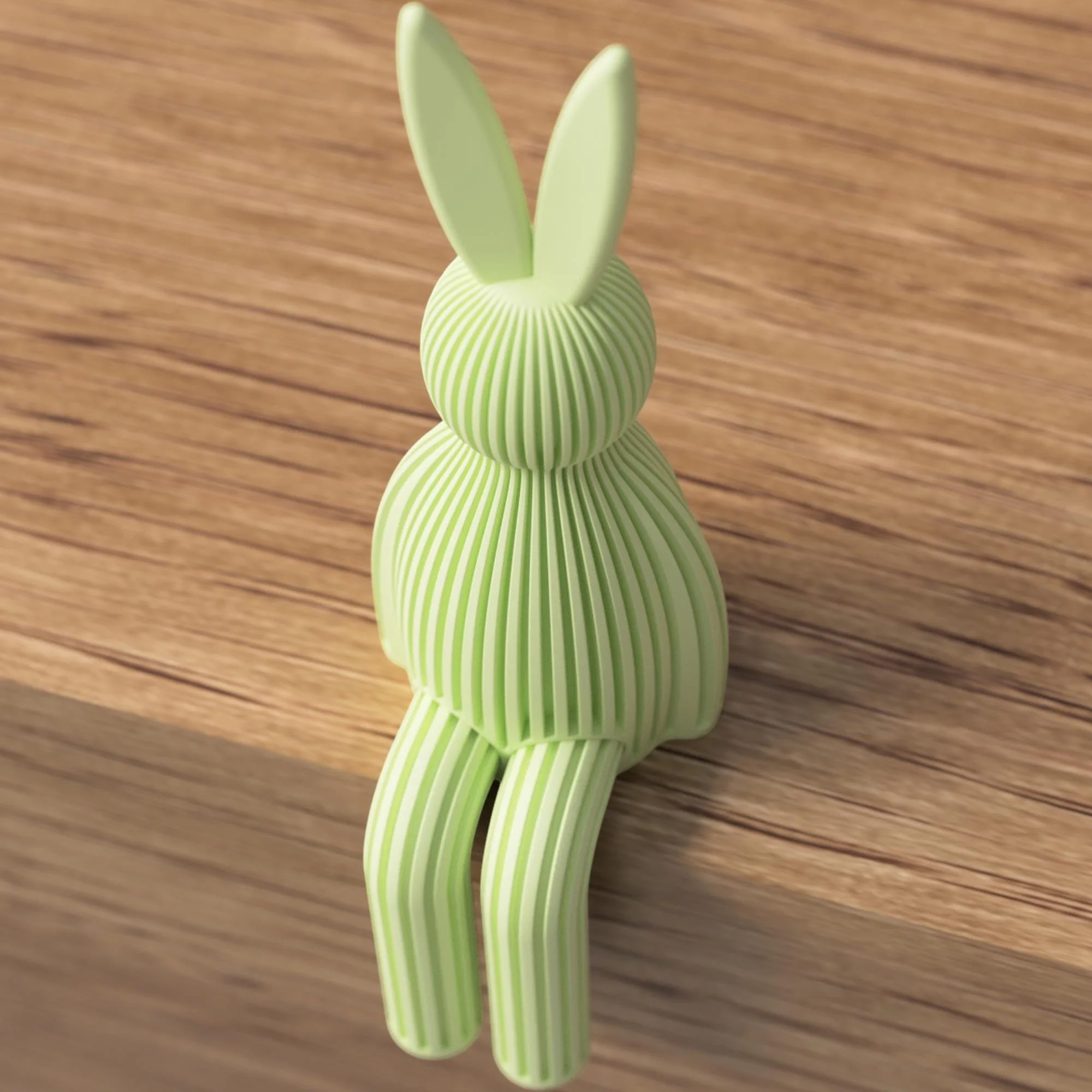 Hellgrüner Japandi Osterhase mit gerippter Struktur, sitzend auf Holz als moderne Osterdeko mit langen Ohren und hängenden Beinen.
