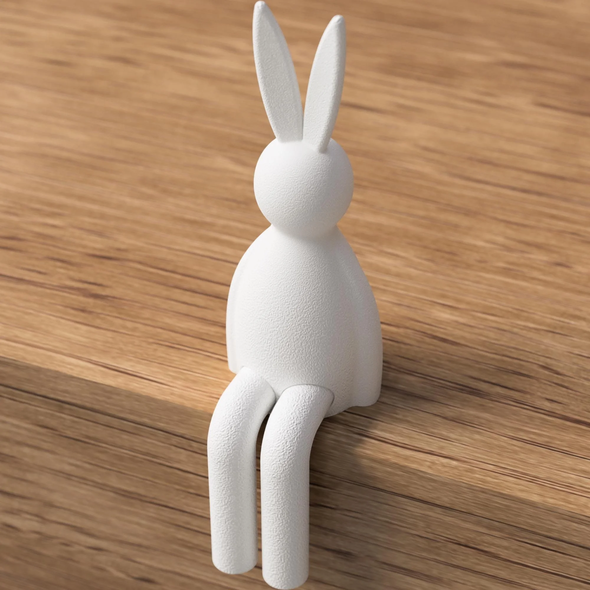 Weißer Osterhase mit glatter Oberfläche in schlichter Sitzform auf Holz, minimalistische Dekofigur mit langen Ohren und hängenden Beinen.